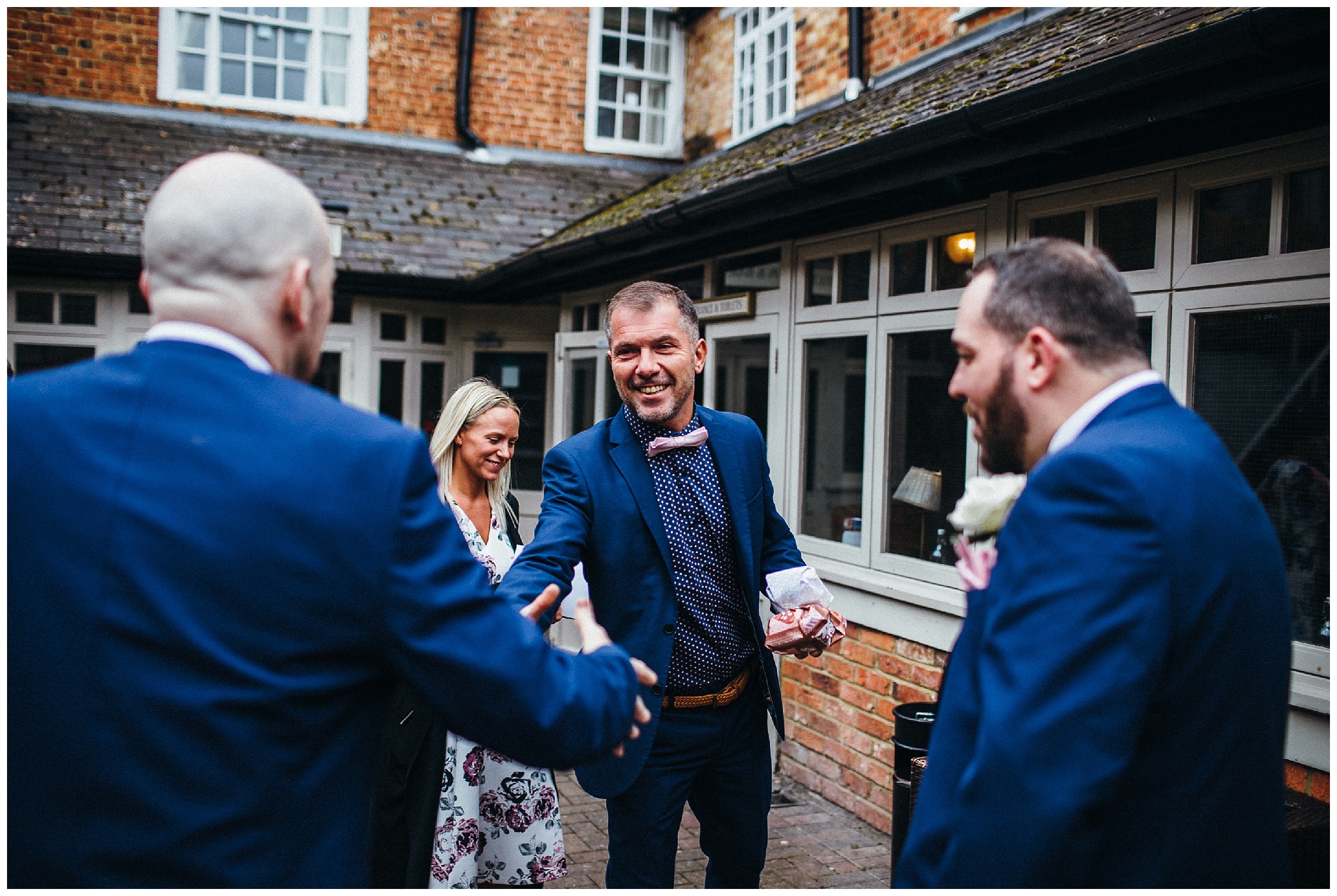 groom greeting guests at cock hotel wedding