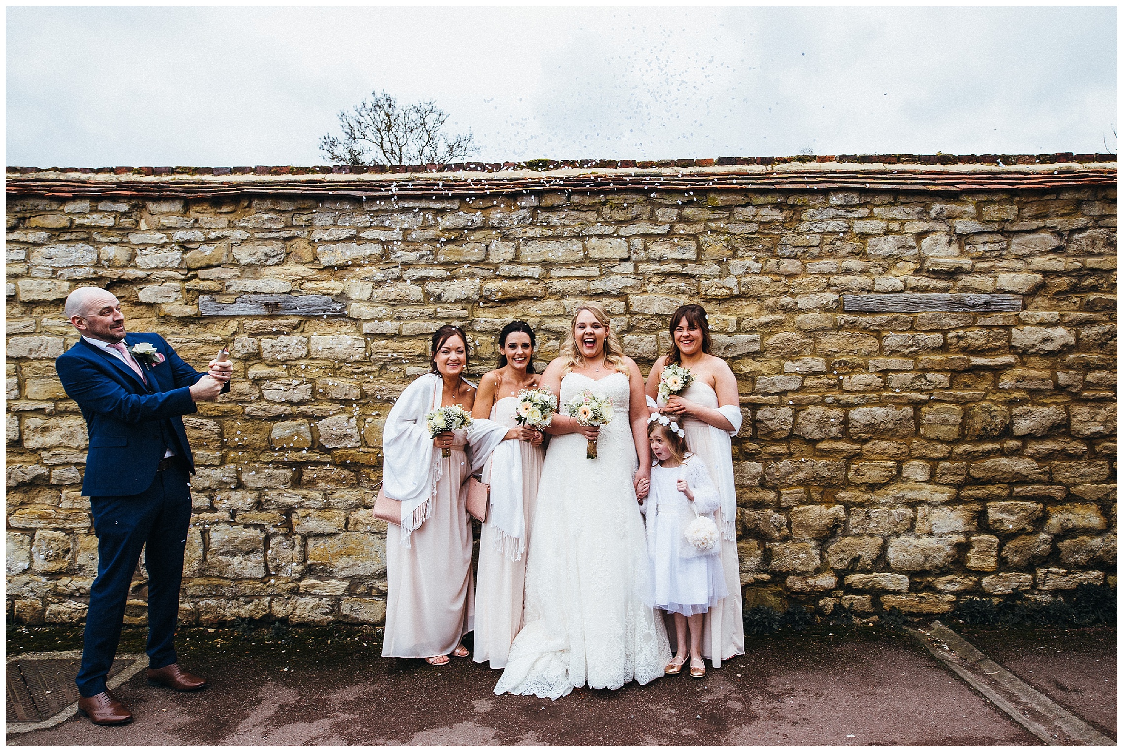 bride and bridesmaid with confetti at the cock hotel in stony stratford