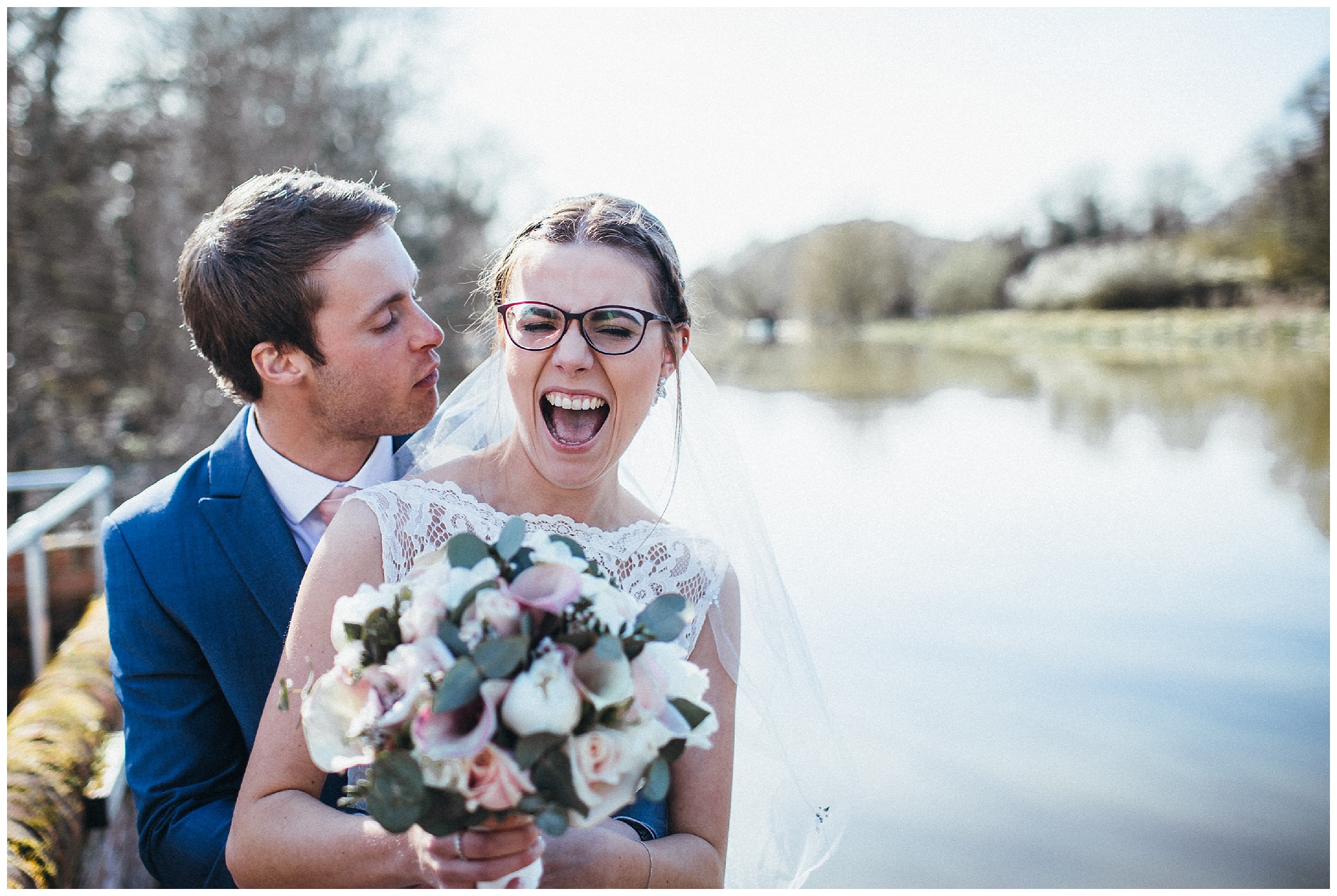 bride laughing hysterically as groom nuzzles her face