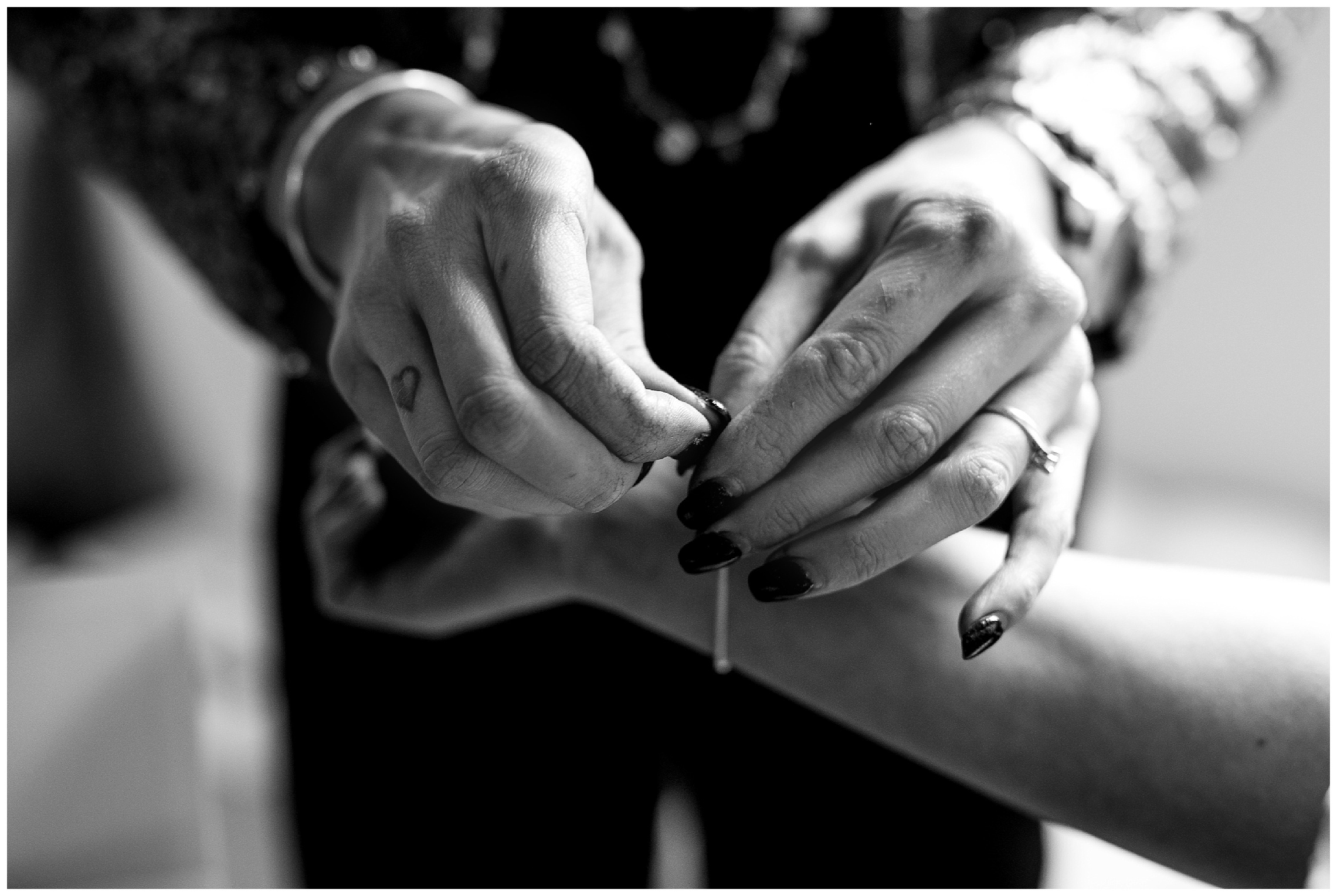 finishing touches as friend helps bride put bracelet on