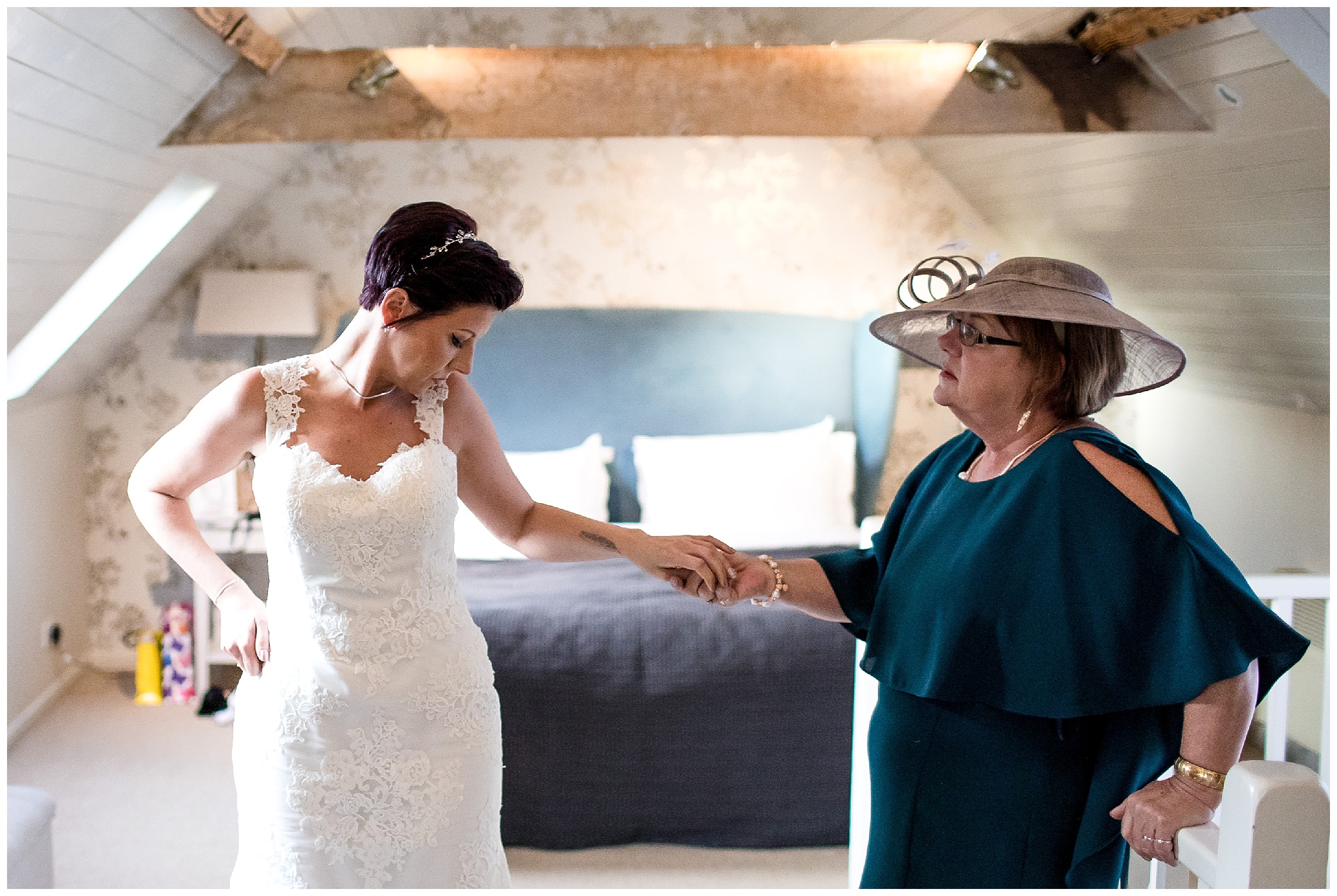 mother of the bride helps bride steady herself getting ready for the ceremony at south farm
