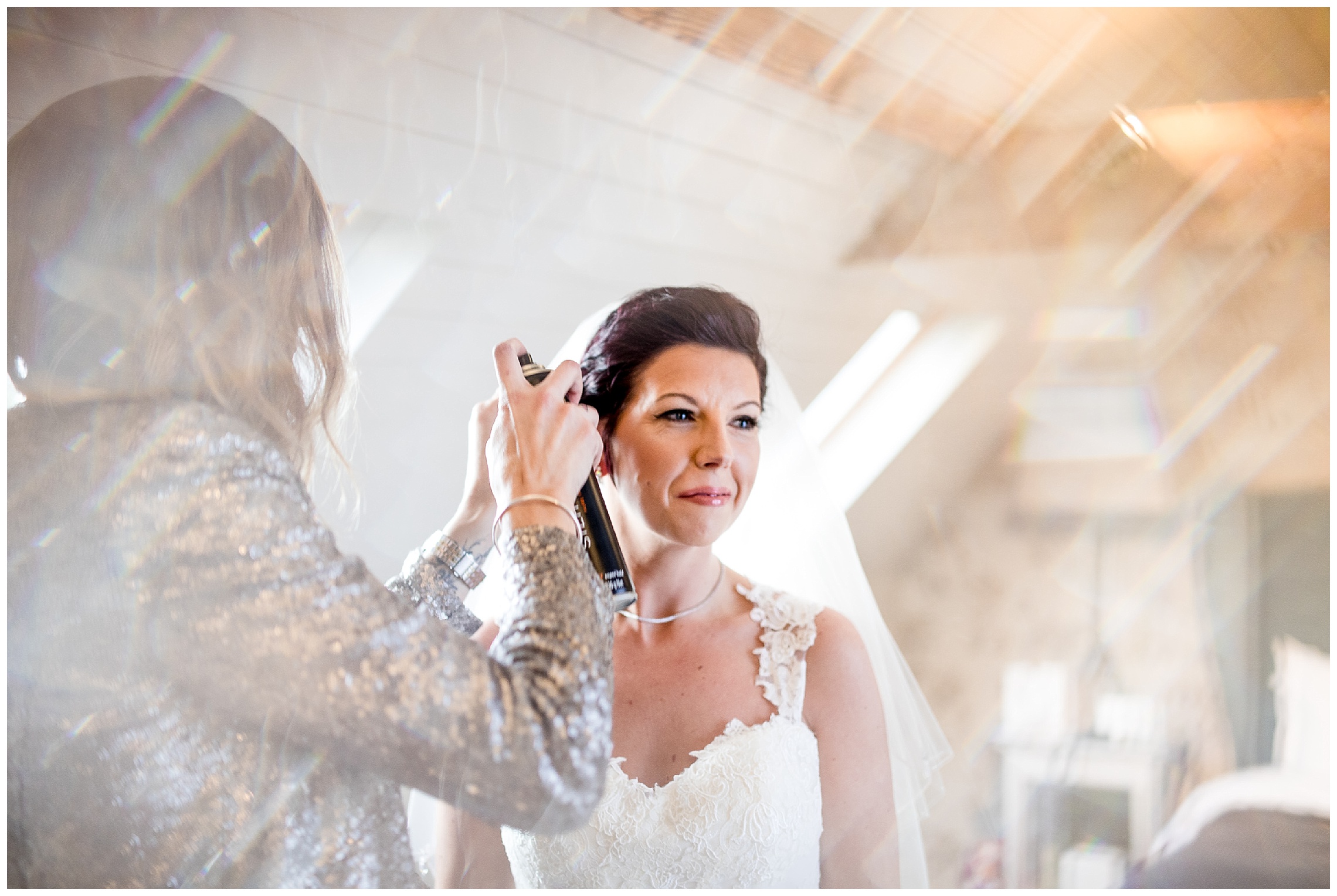 hairdresser applies finishing touches to the brides short hair at south farm