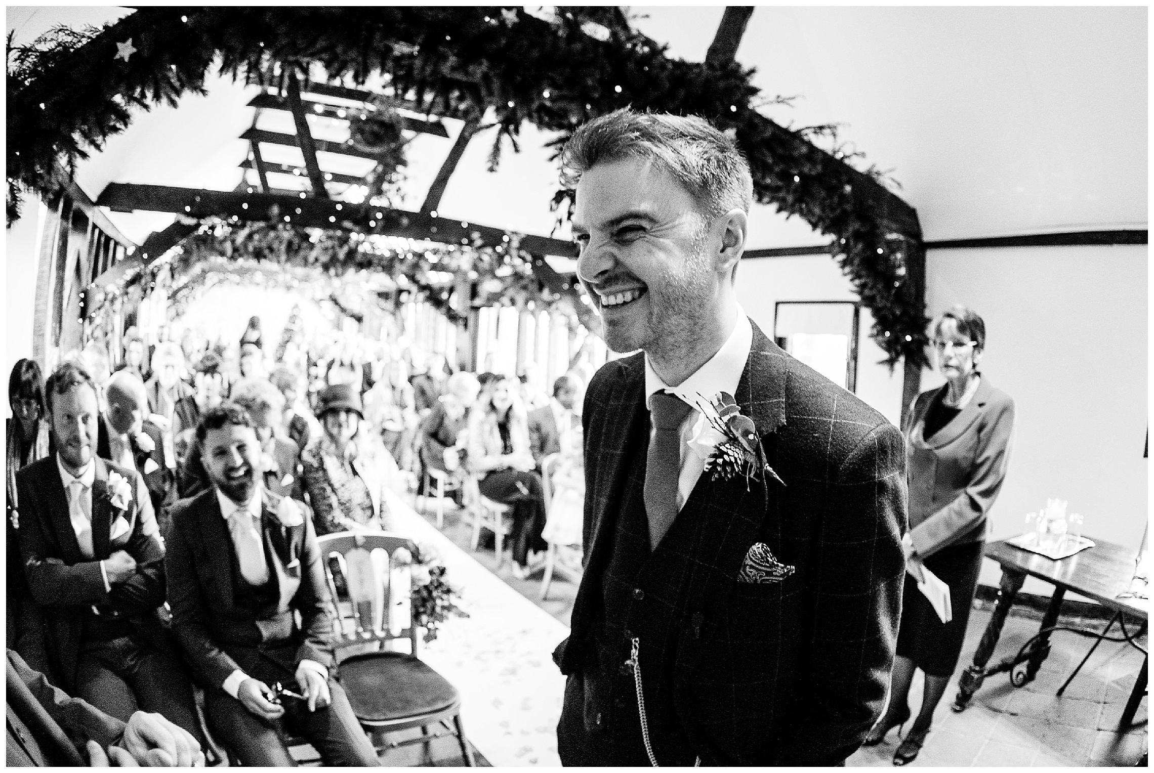 groom laughing with his groomsmen as he waits for the bride