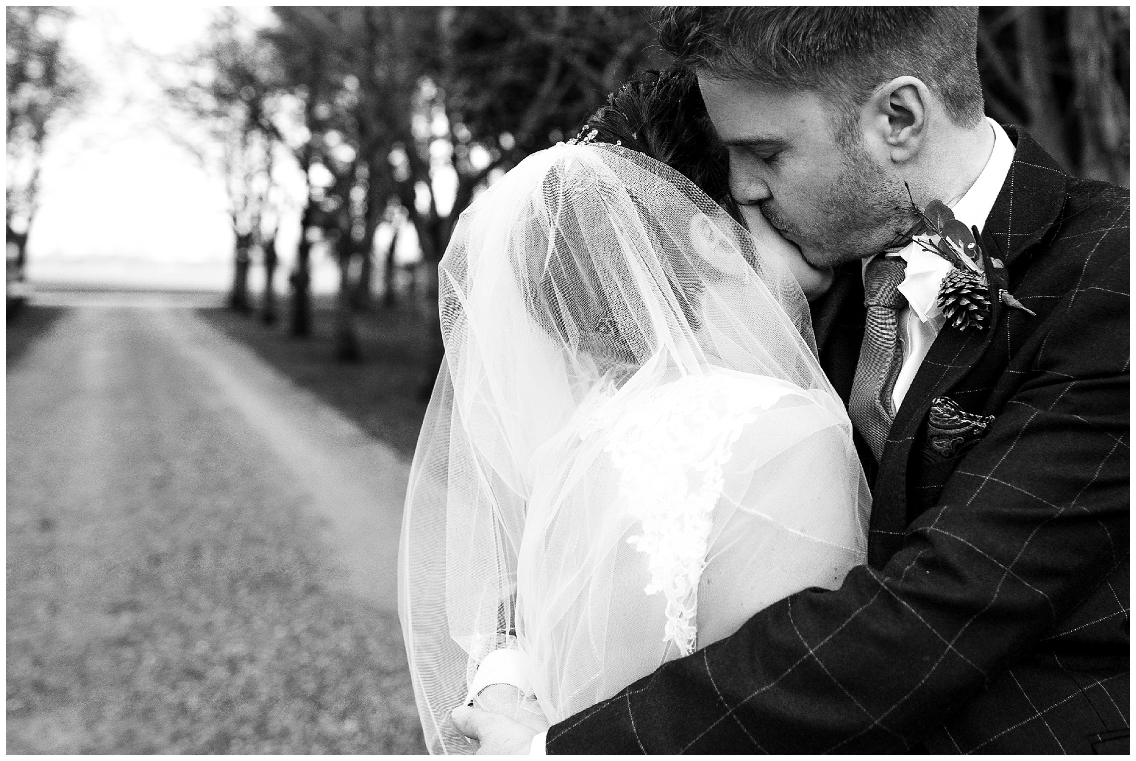 groom kisses his bride on the cheek at south farm