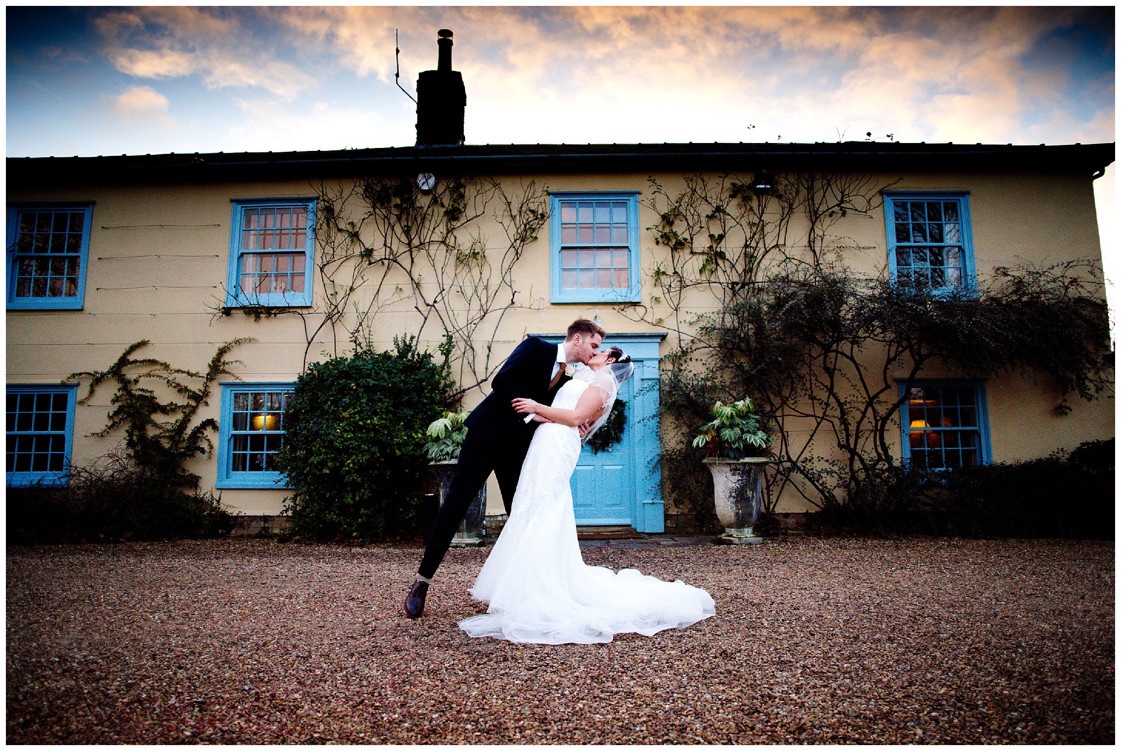 bride is leaned back for a kiss from the groom on their wedding day at south farm