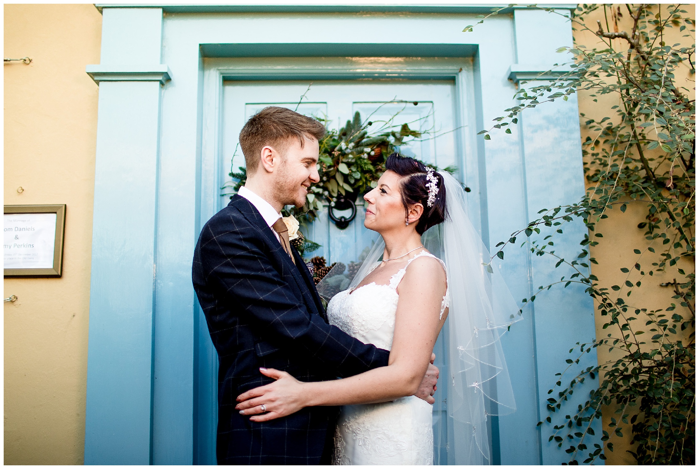 bride and groom in front of the iconic blue door at at south farm wedding venue