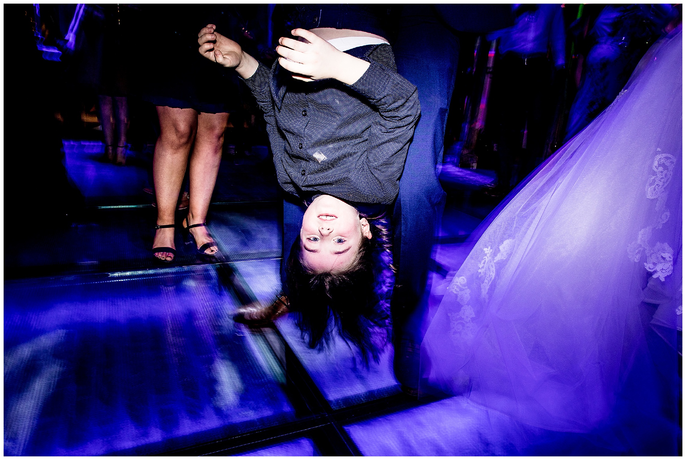ittle boy being held upside down by his dad on the dance floor at south farm