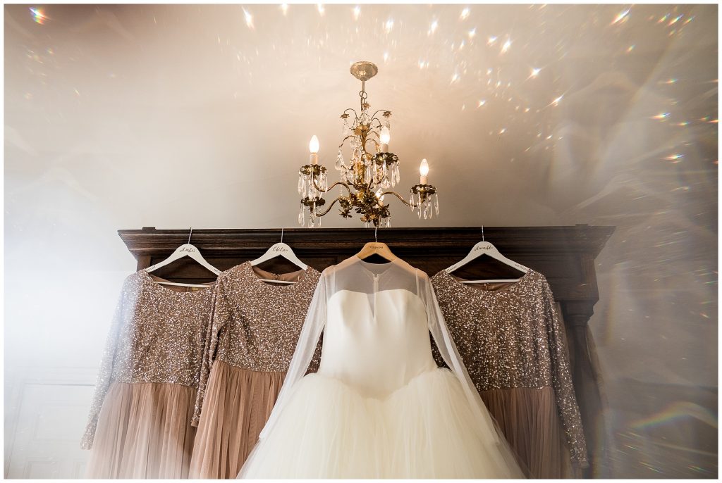 Vera Wang bridal dress and bridesmaid dresses hanging on bed