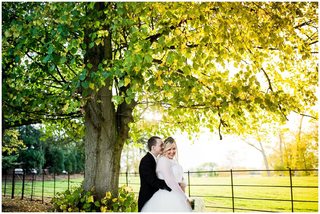 bride and groom stand close together and bride laughs