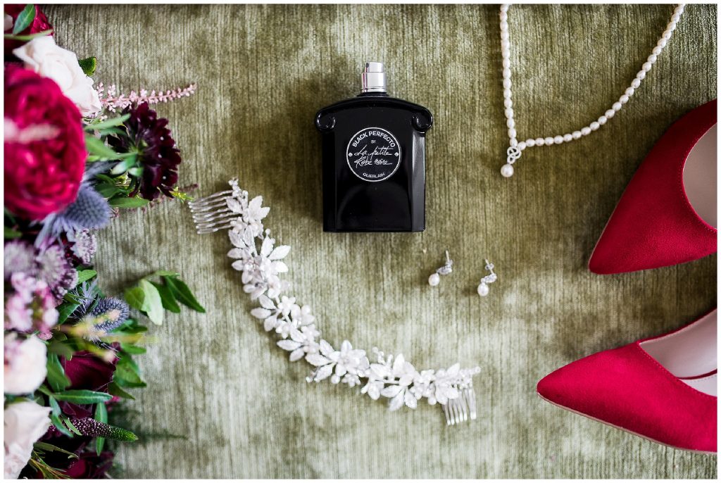 bride details, perfume and jewellery on bed 