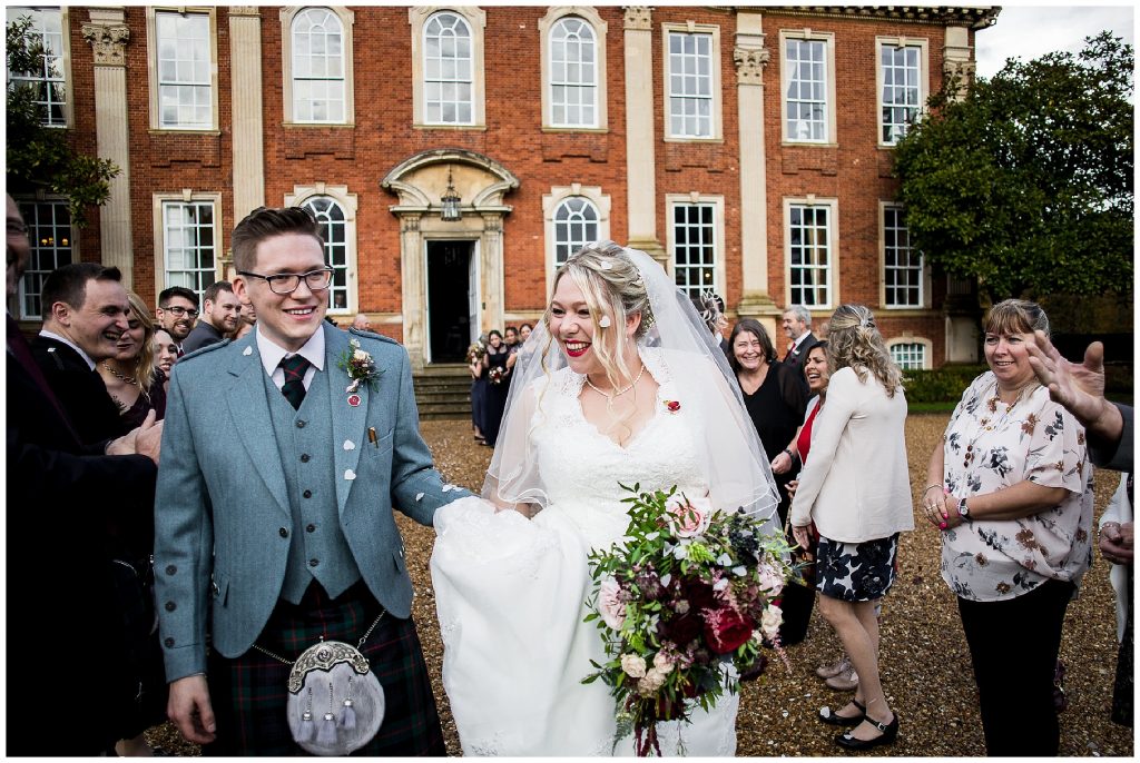 bride and groom walk through confetti tunnel at chicheley