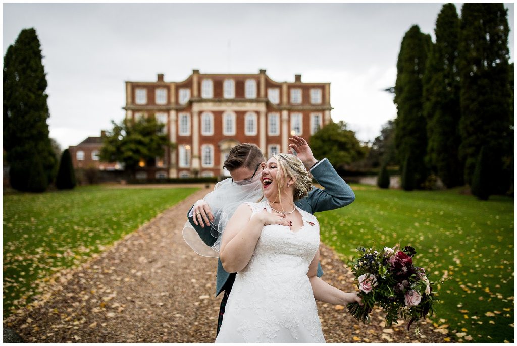 groom gets caught in brides veil and they both laugh