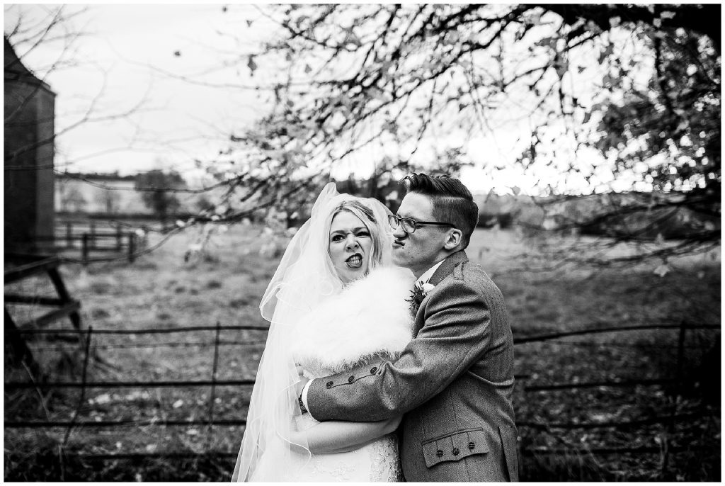 black and white image of bride and groom pulling funny faces 