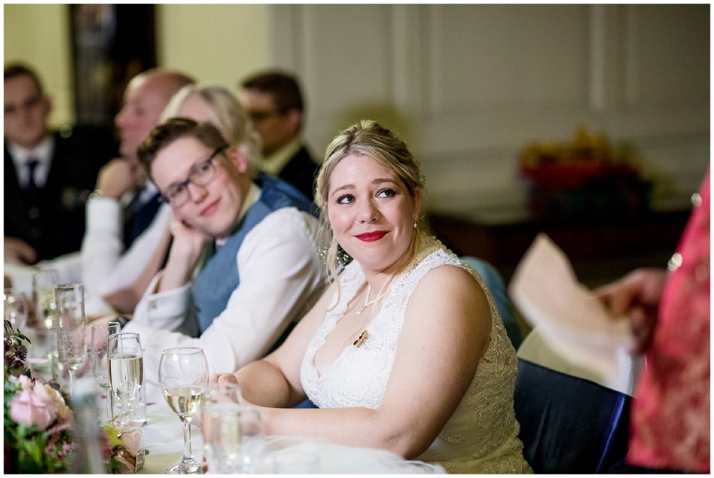 bride looks at groom and cries during wedding speech