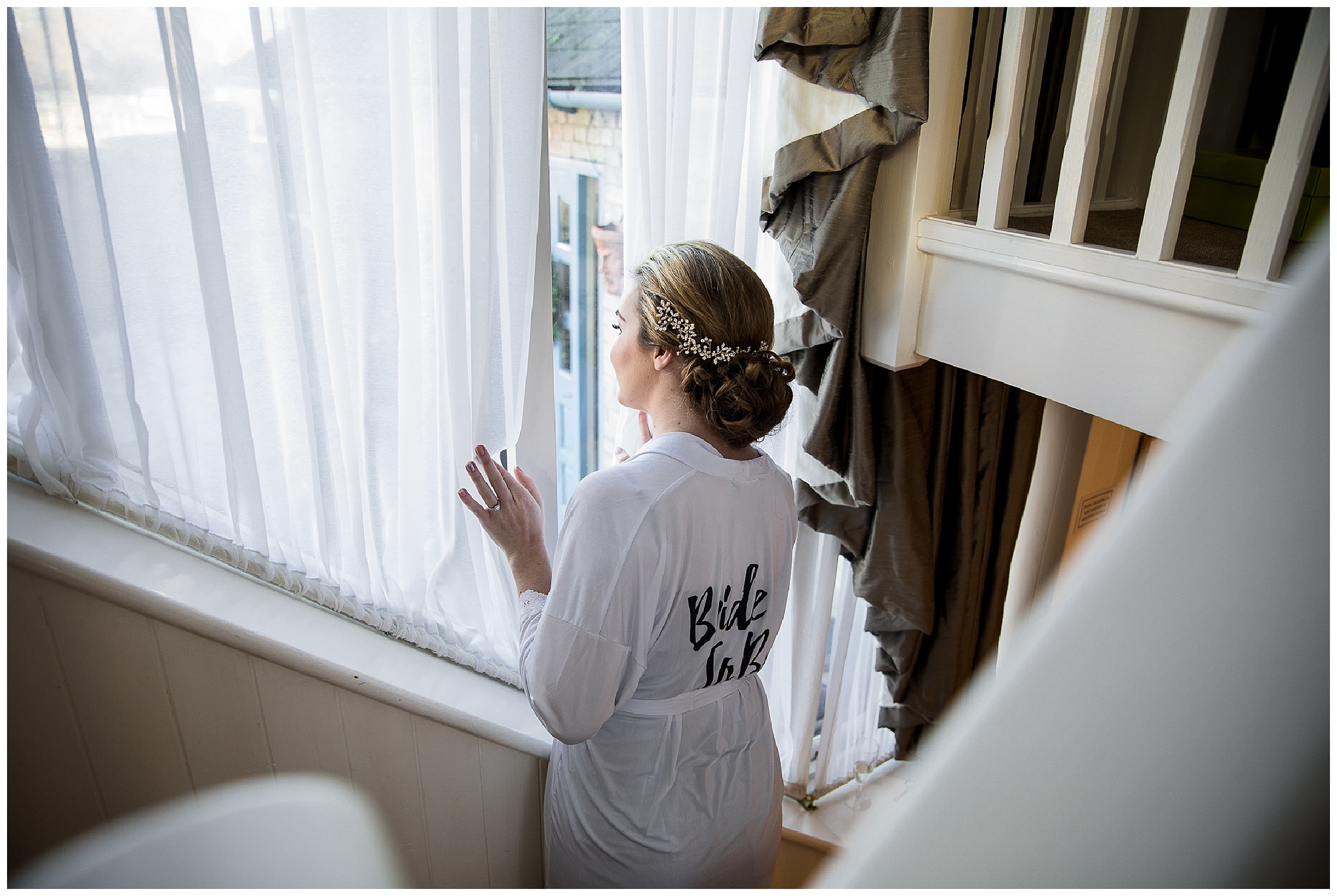 bride looking out of window in bridal gown