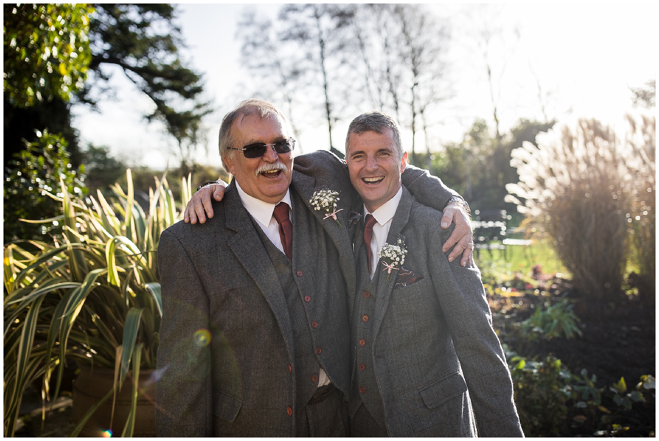 Grooms dad and brides dad outside together in suits