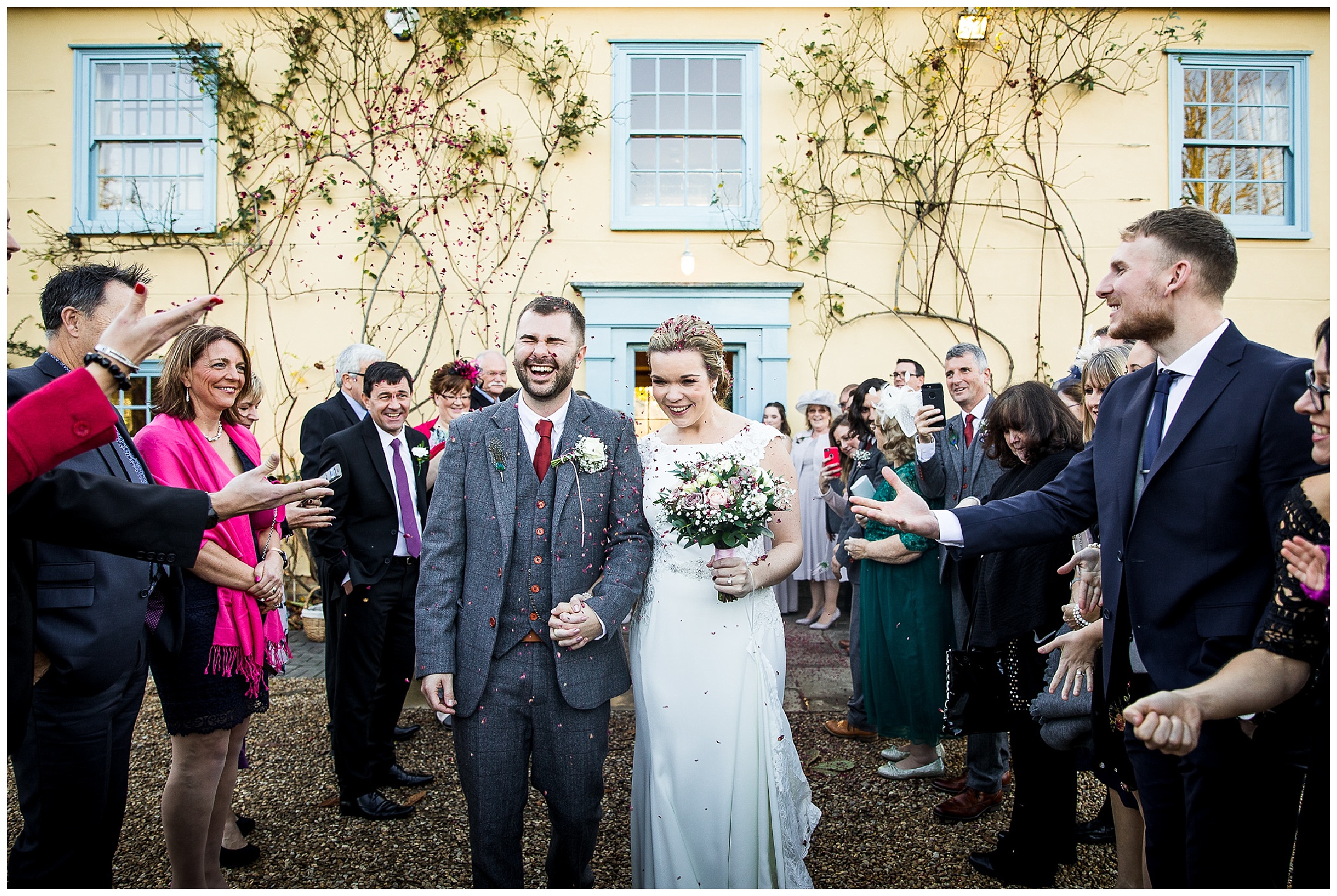 bride and groom walk together under tunnel of confetti