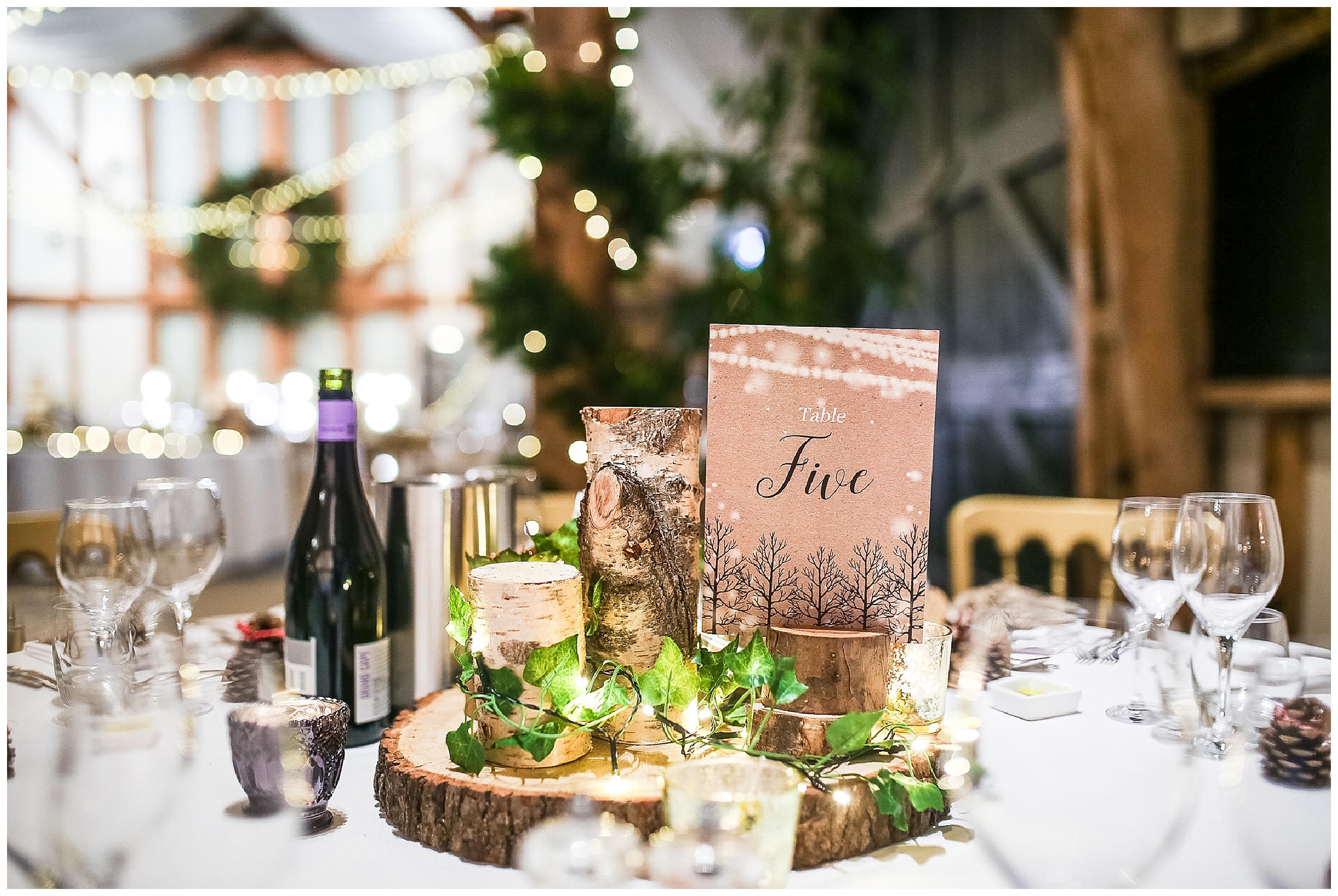 winter wedding centrepieces with wooden logs and fairy lights
