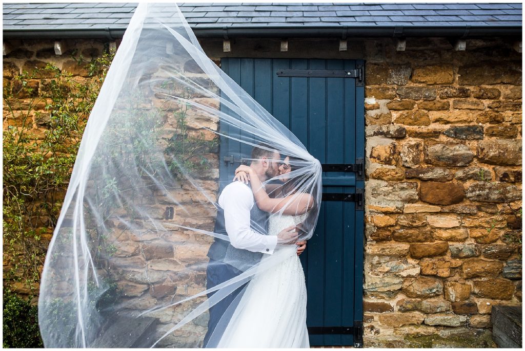 bride and groom under veil