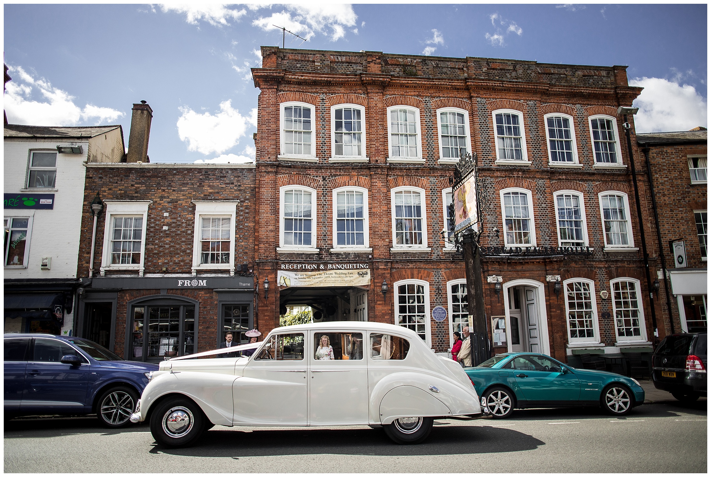 White bridal car waits outside hotel for bride