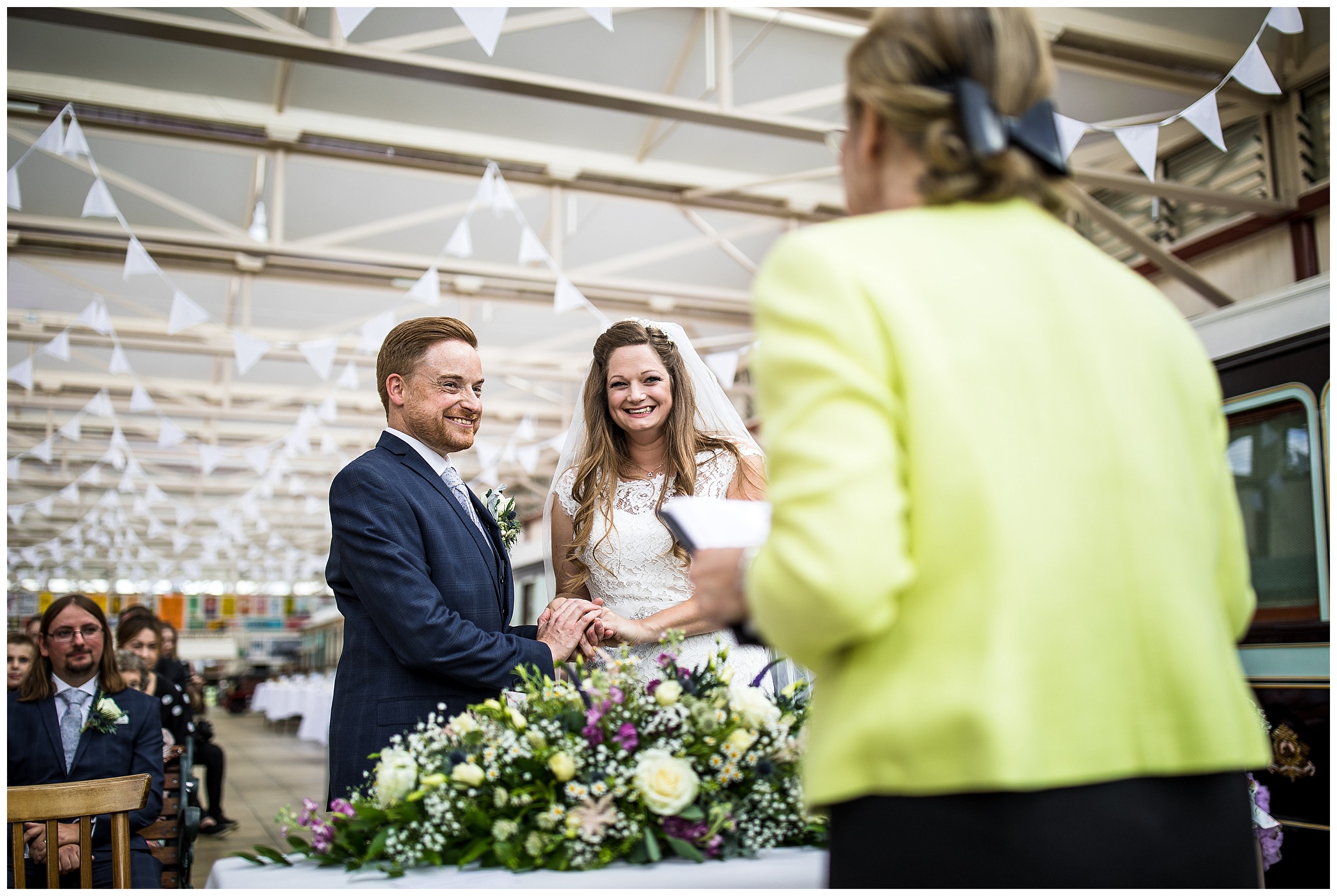 bride and groom stand in front of celebrant at bucks railway centre