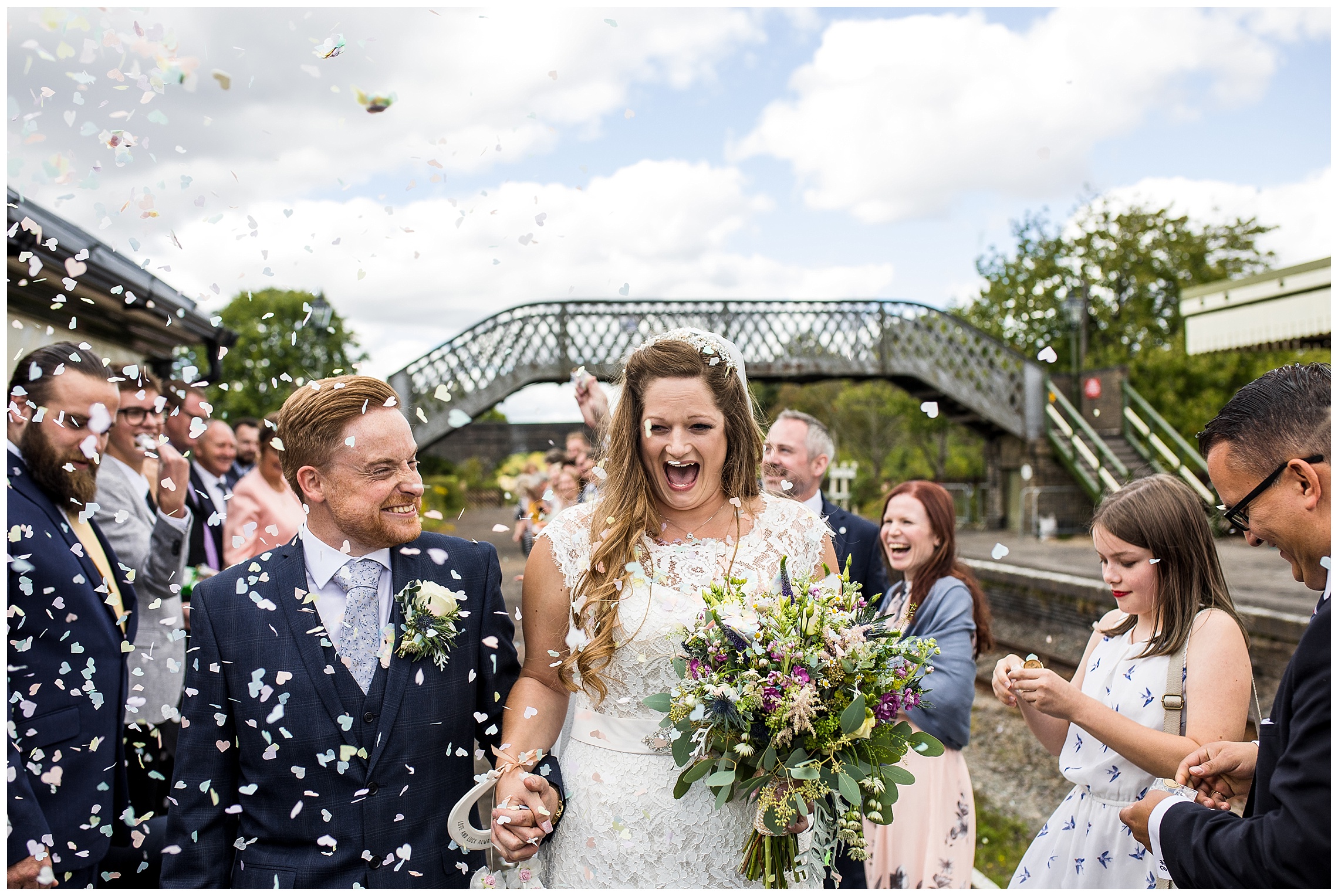 bride and groom hold hands and run under confetti laughing, at bucks railway centre