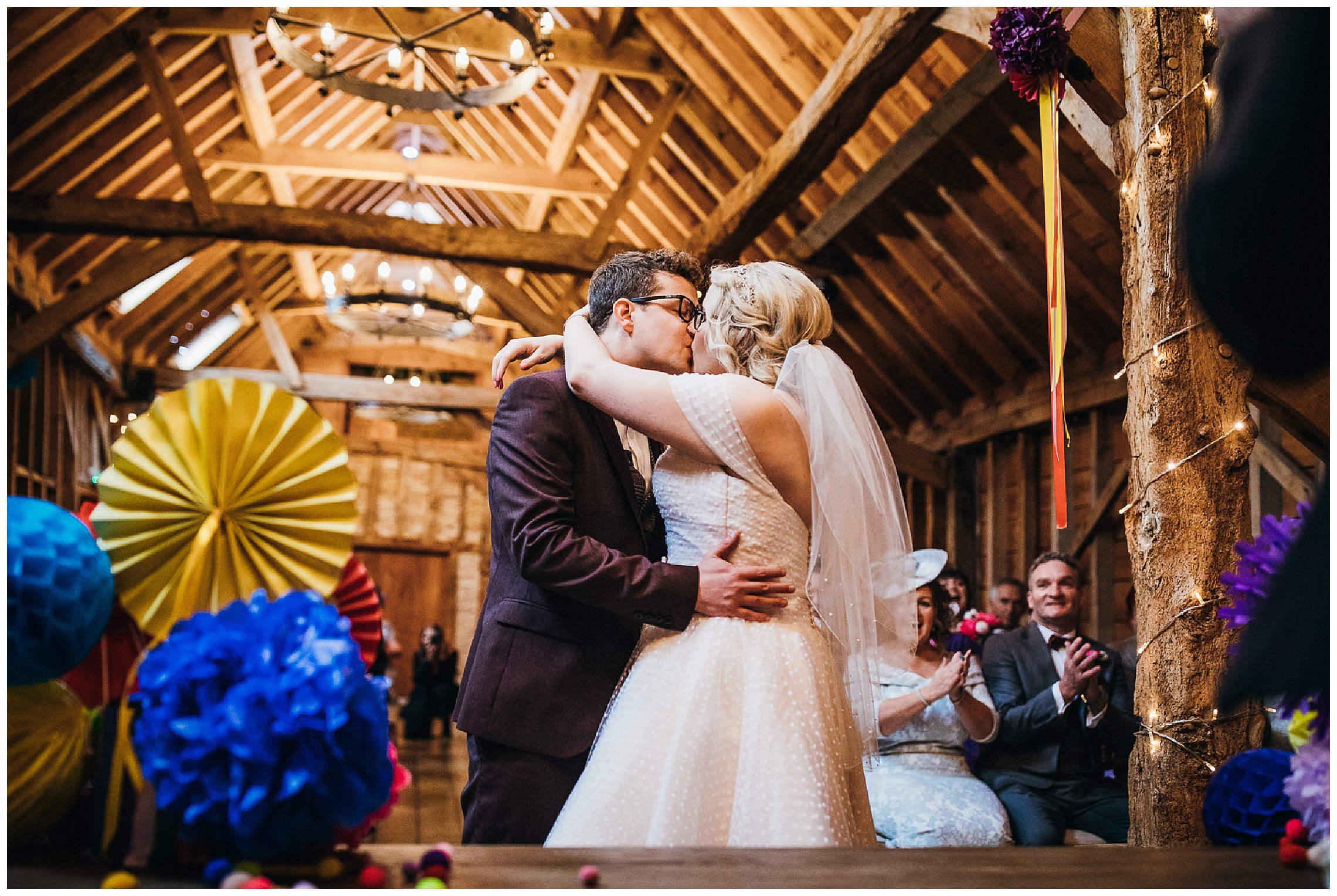 Bride and groom kissing in rickety barn at Bassmead