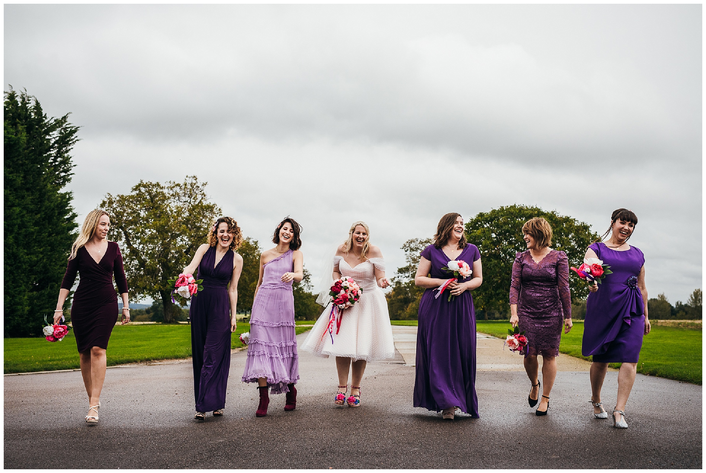 bridesmaids and bride walk down driveway at bassmead in time to Ru Paul's music