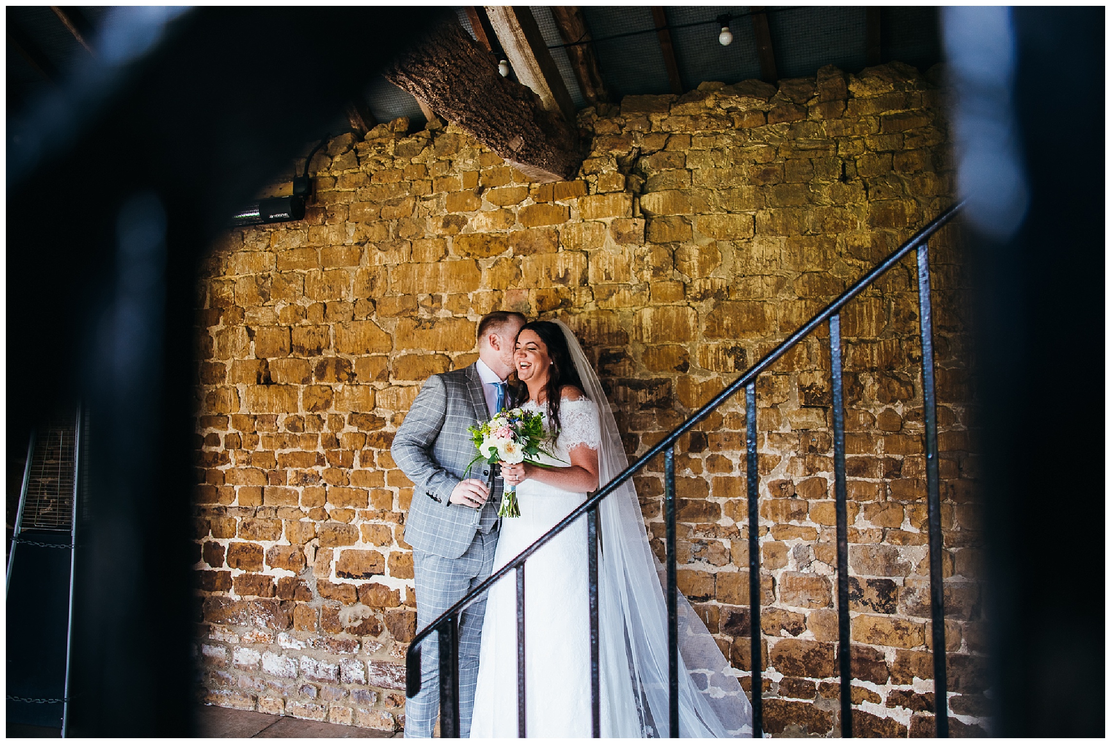 Bride and groom stand together and laugh on their wedding day