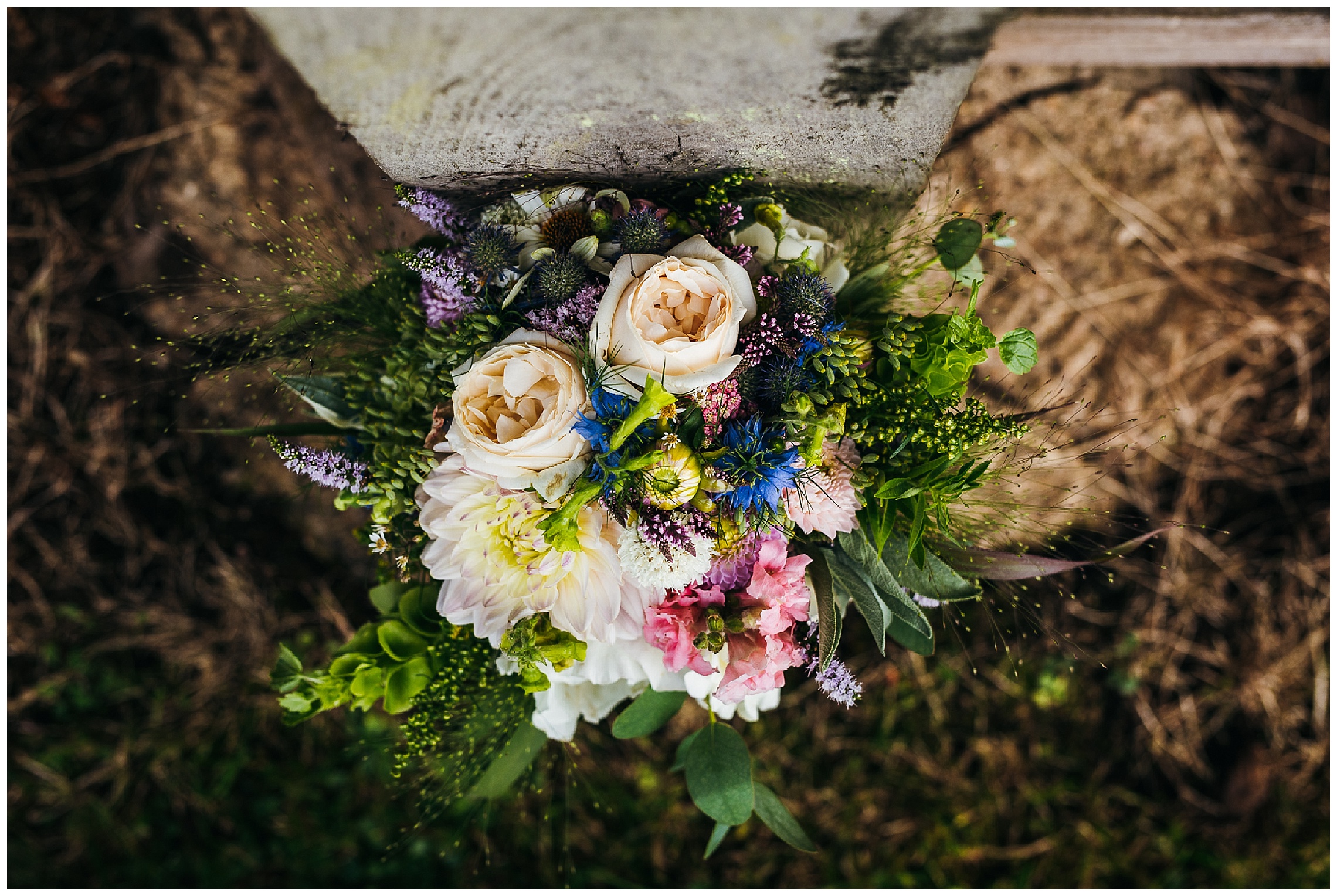 bright wedding flowers with pink, yellow and blue flowers surrounded by greenery and foliage