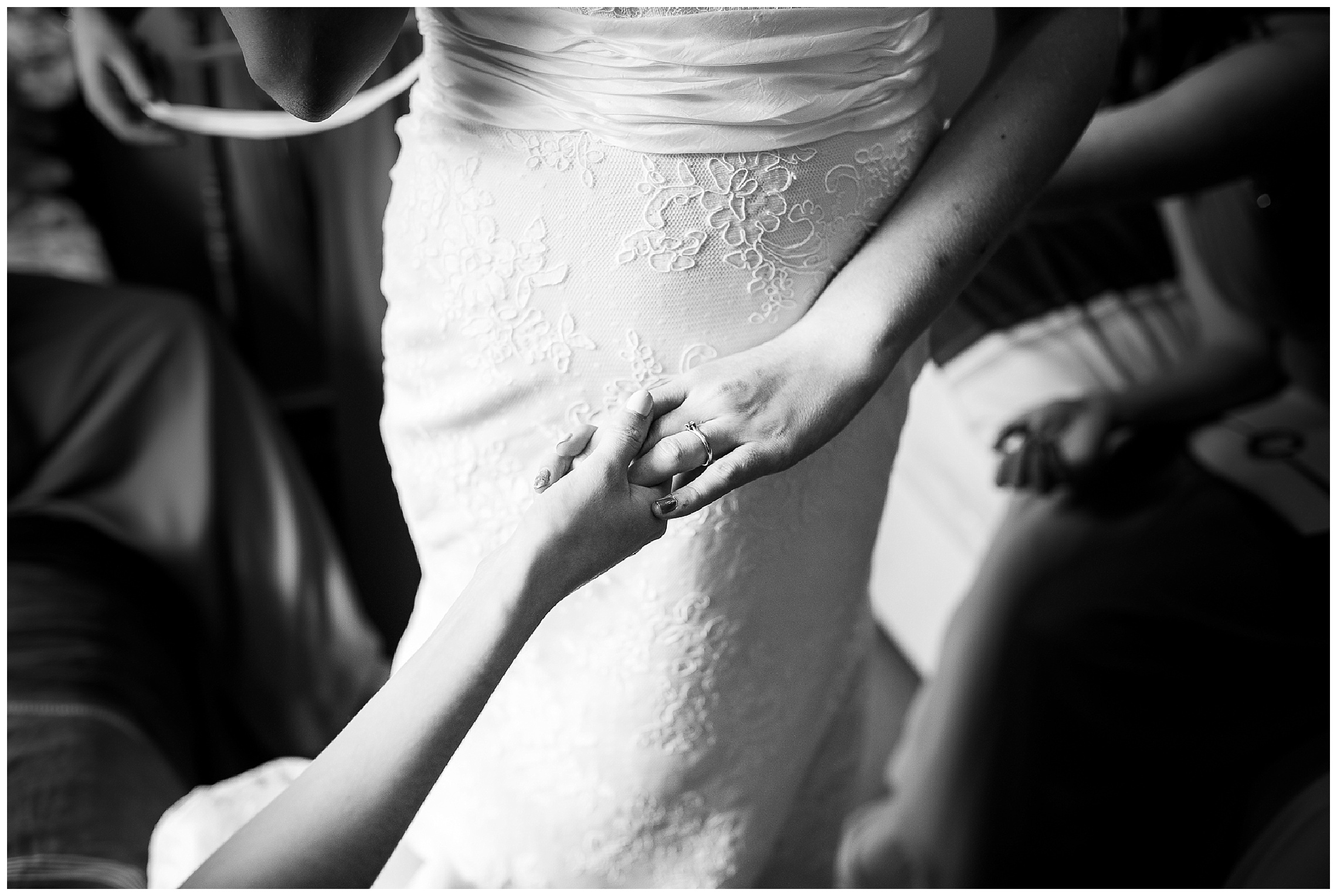 bride holds her friends hands as she gets ready on the morning of her wedding