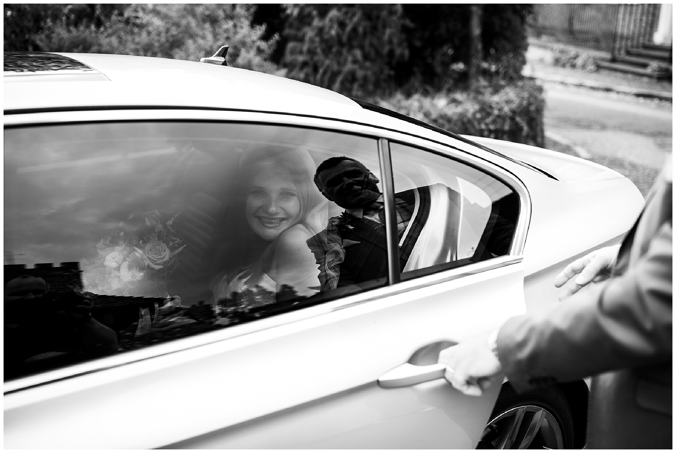 Bride smiling with reflection of her dad in car window