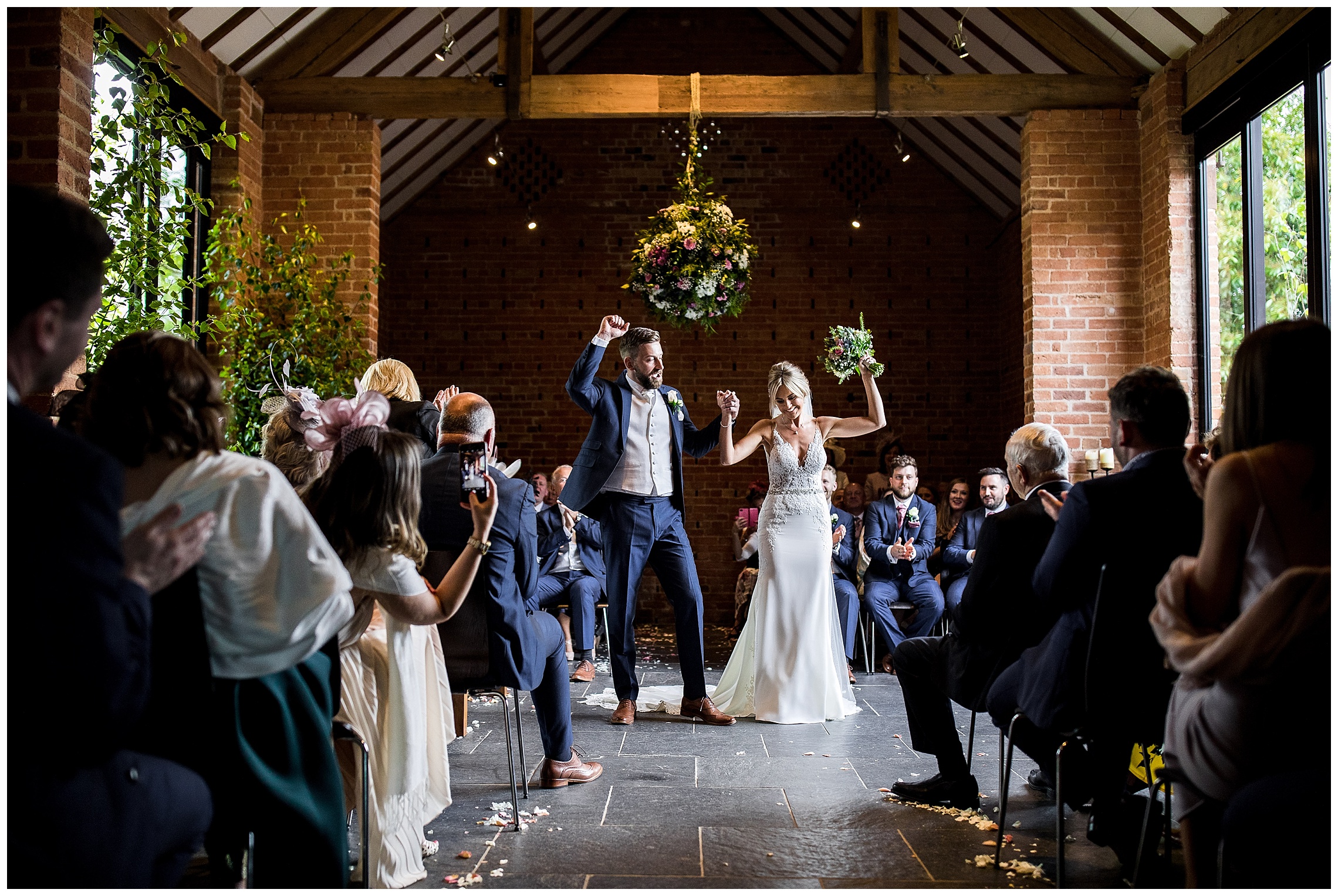 bride and groom celebrate with arms in air in front of all of their guests