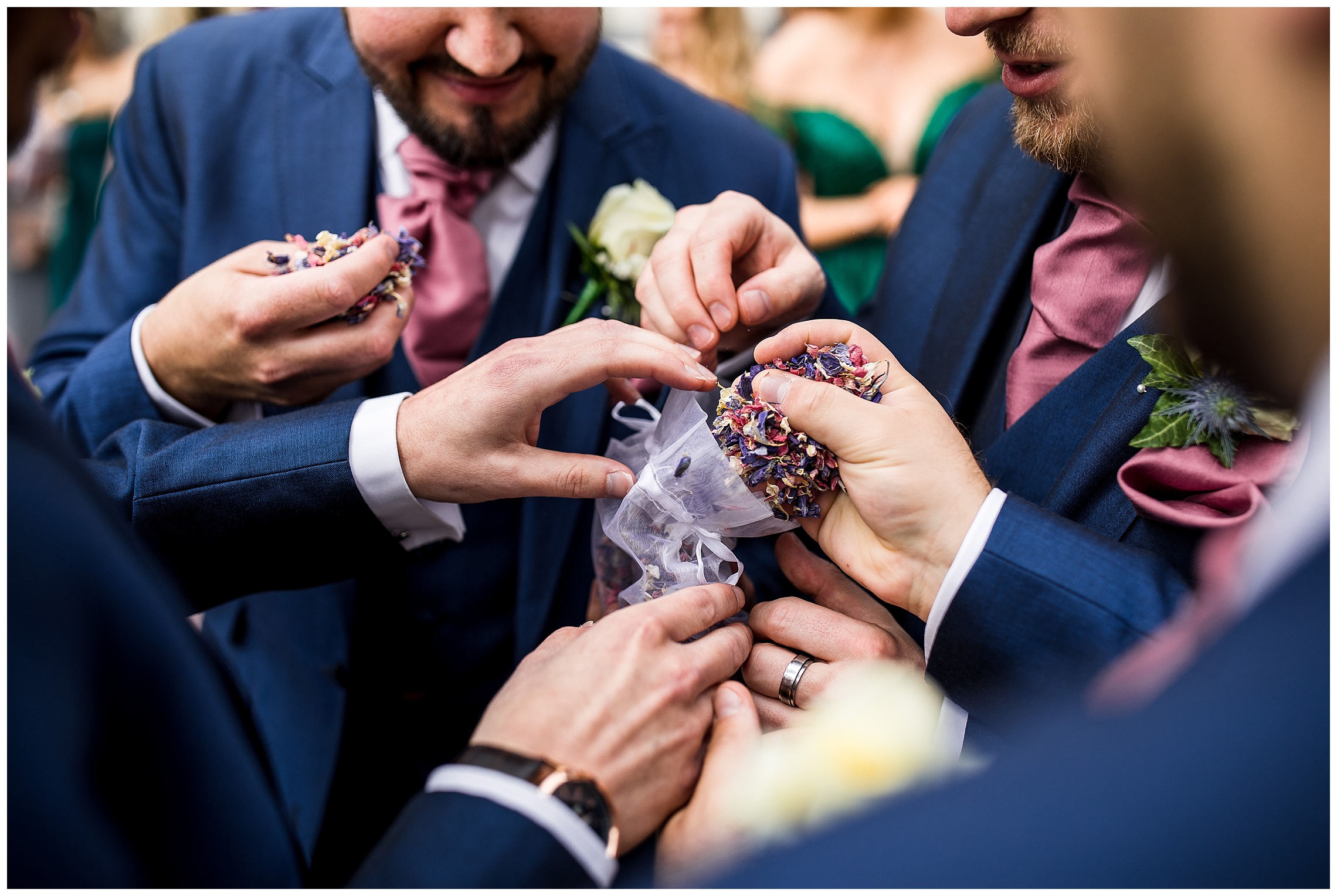 groomsmen holding onto red petal confetti