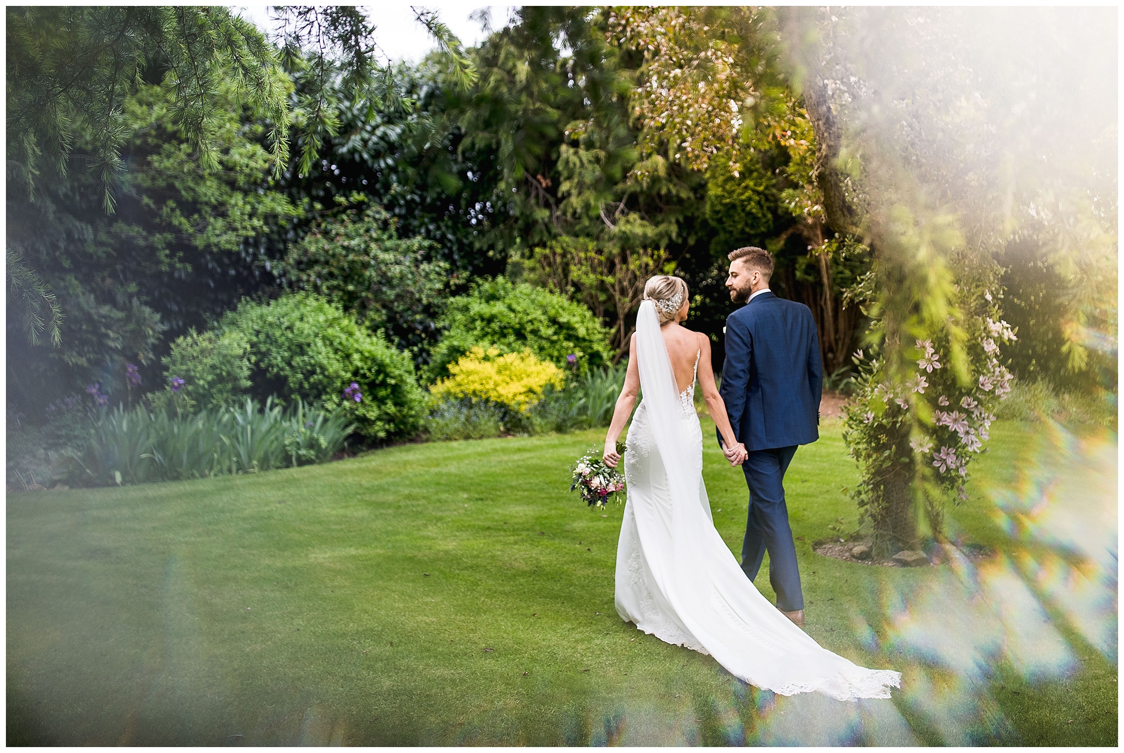 bride and groom walking over lawn hand in hand