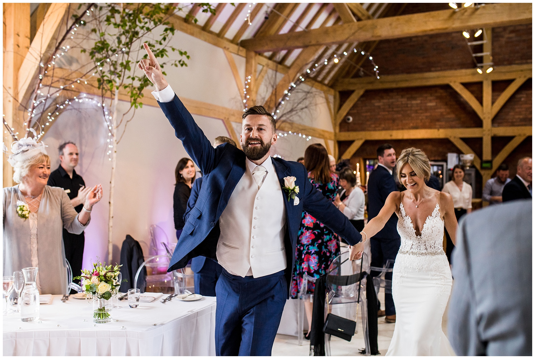 bride and groom entering room and guests cheering at redhouse barn