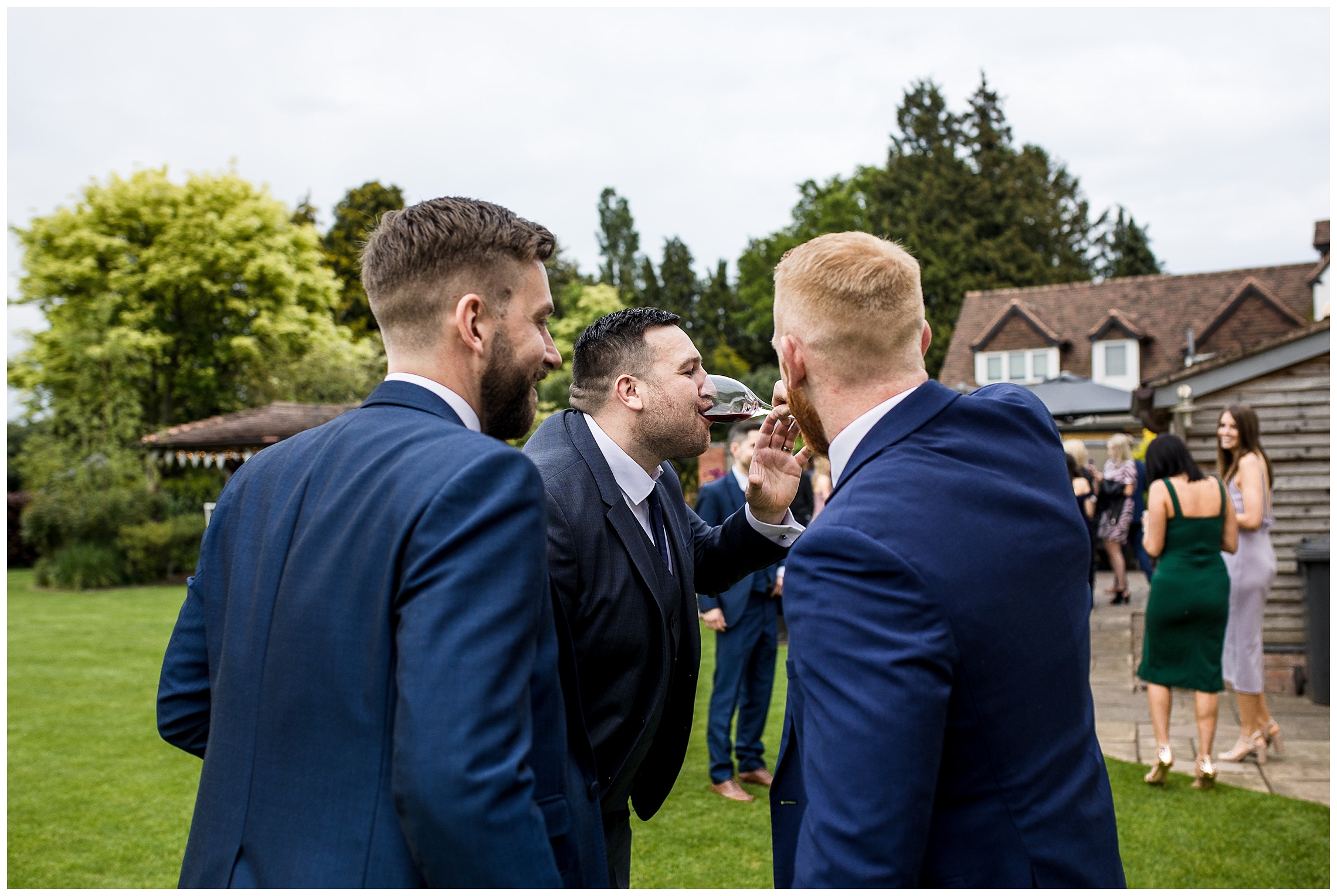 wedding guests pouring red wine into somebody's mouth
