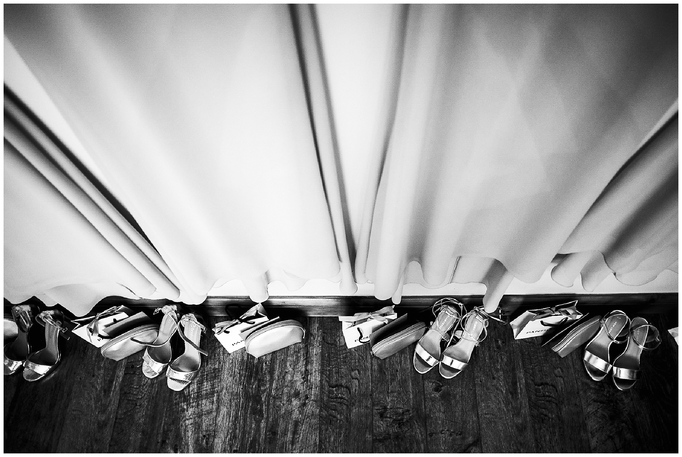 empty bride dresses hanging from picture rail with scrappy shoes beneath them