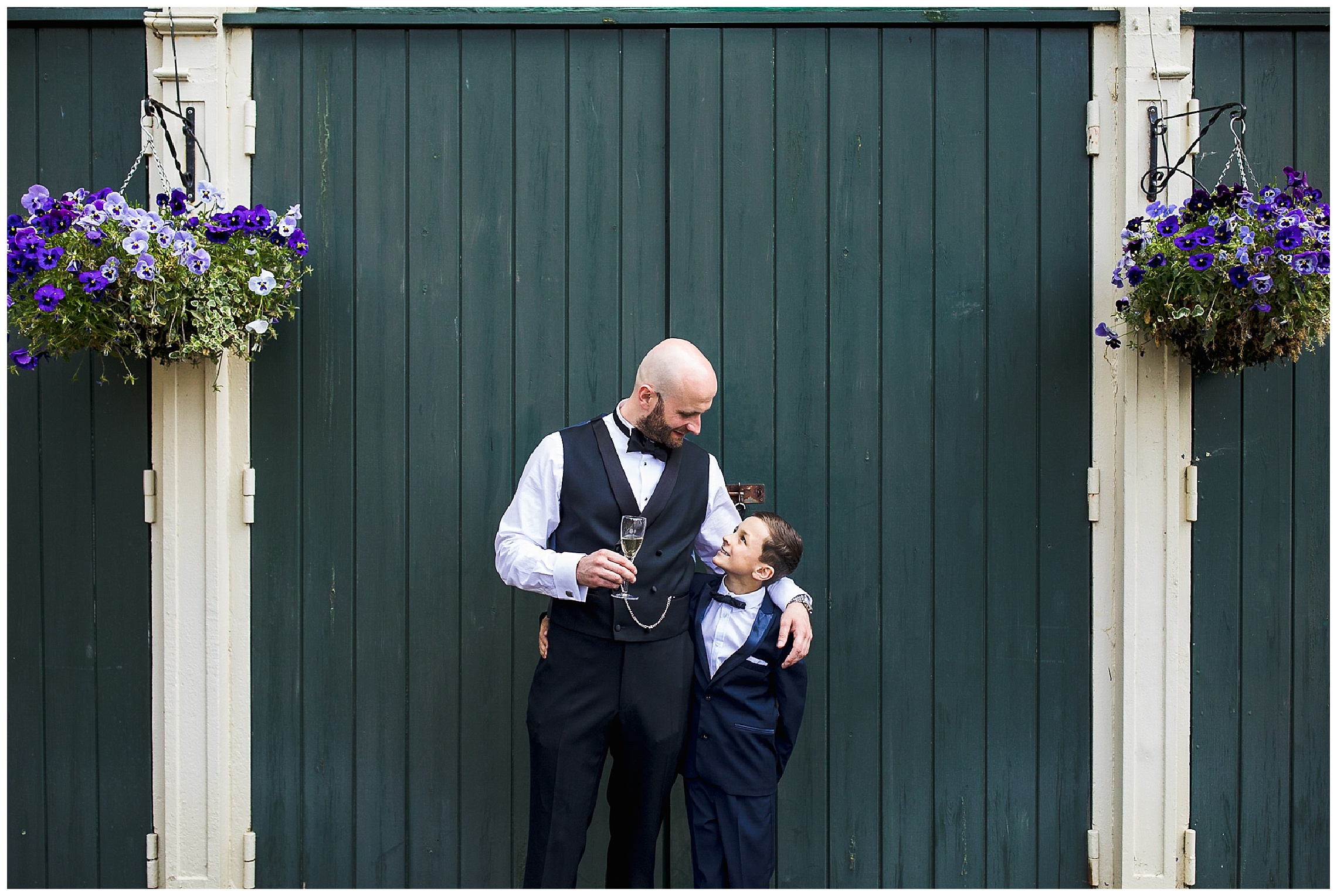 groom in waistcoat looks down at his young son