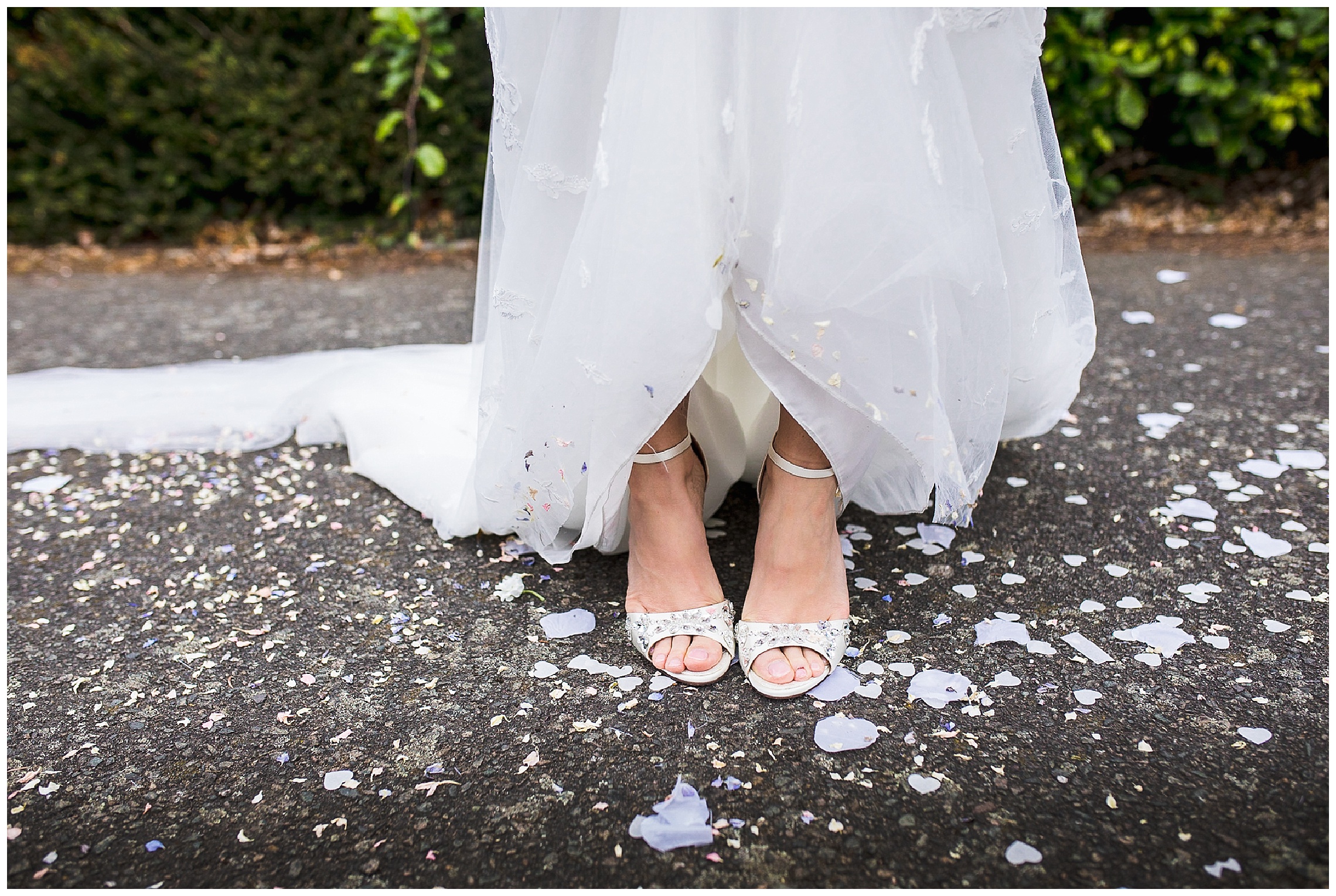 dolce and gabbana wedding shoes on bride holding dress up, surrounded by fallen confetti