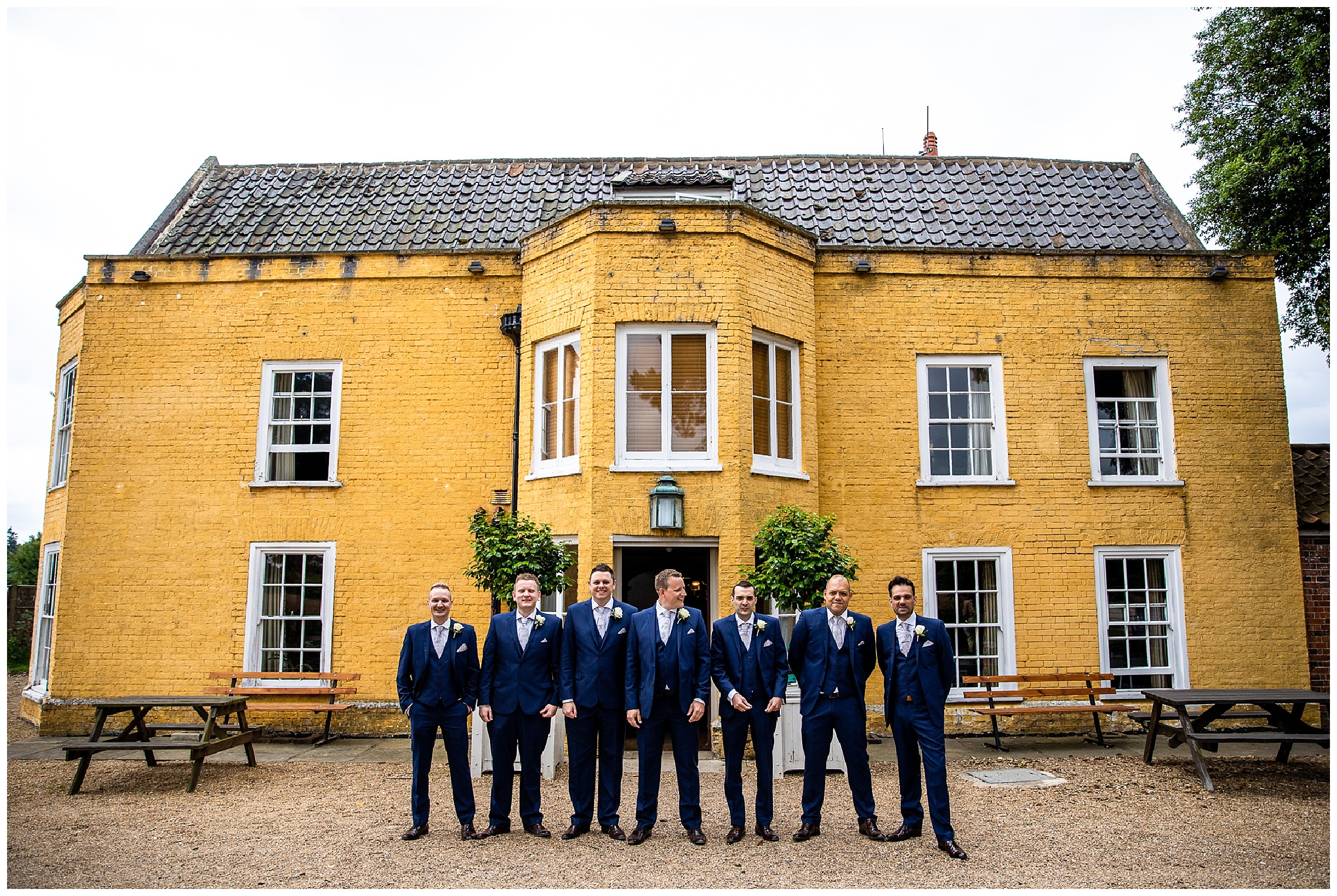 7 men in blue suits outside grand building in norfolk
