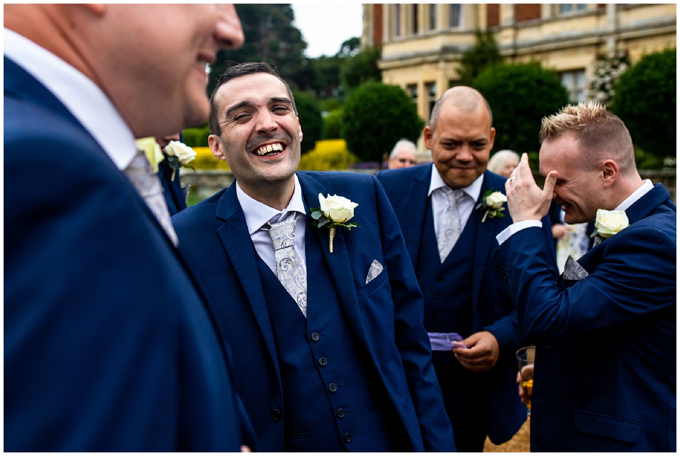 groomsman in blue suit laughing