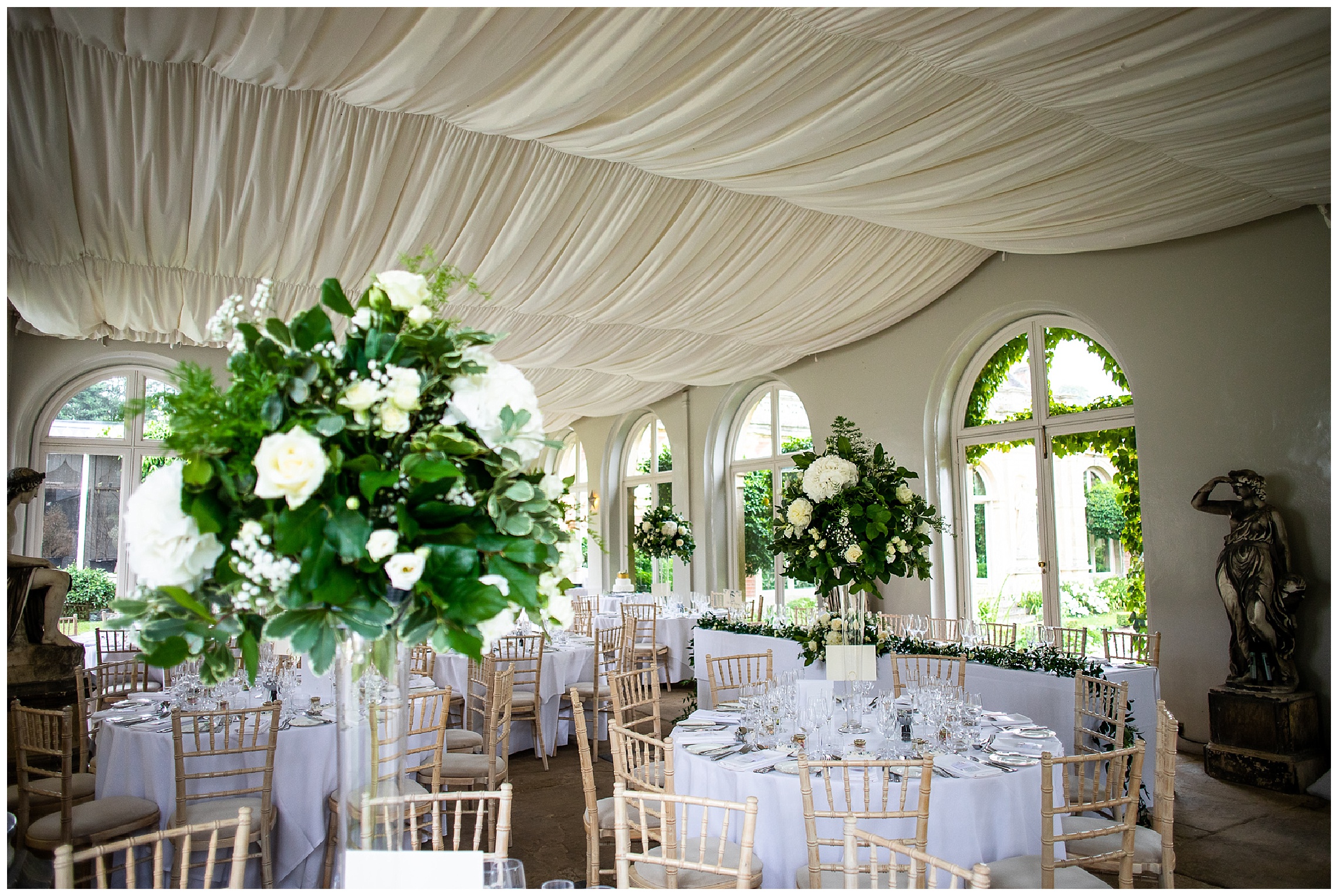 somerleyton marquee venue with white florals and draping fabric