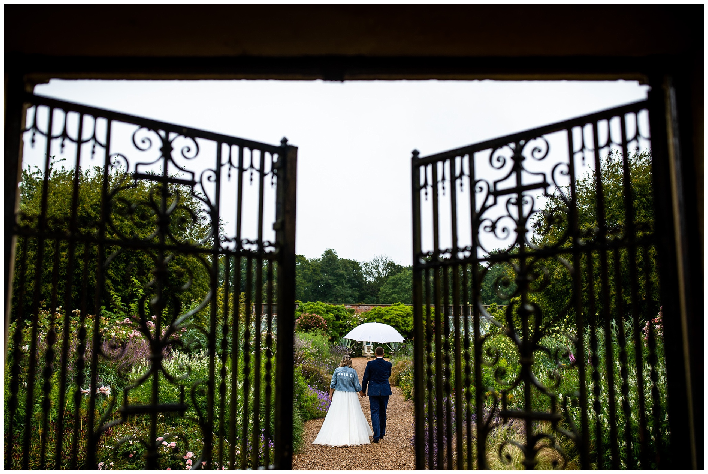 bride and groom walking through garden of somerleyton hall
