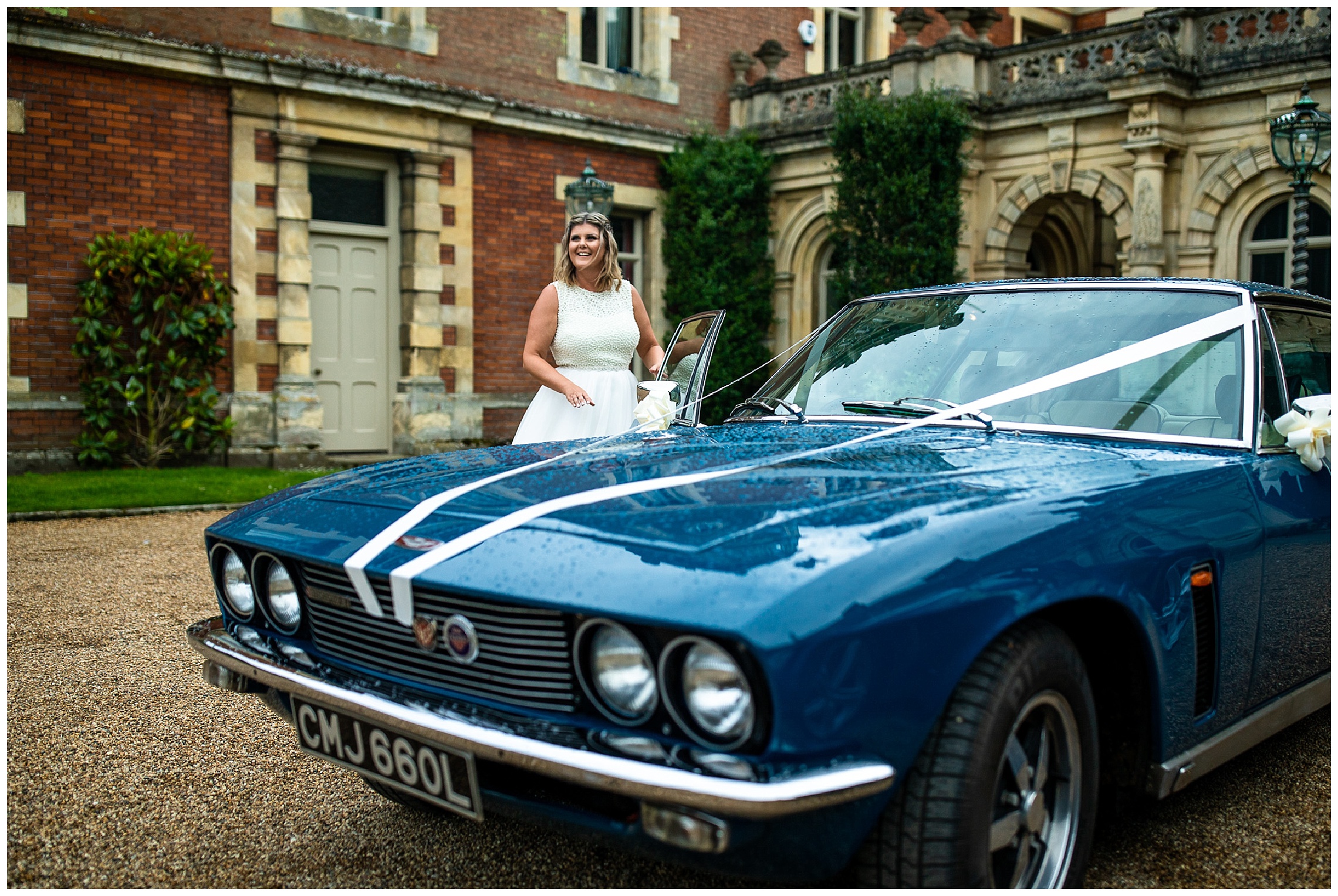 bride laughing as she gets into blue vintage car