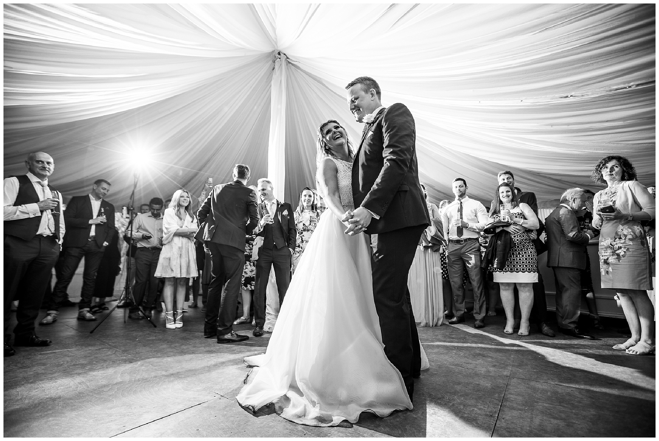 bride and groom dance close together in marquee