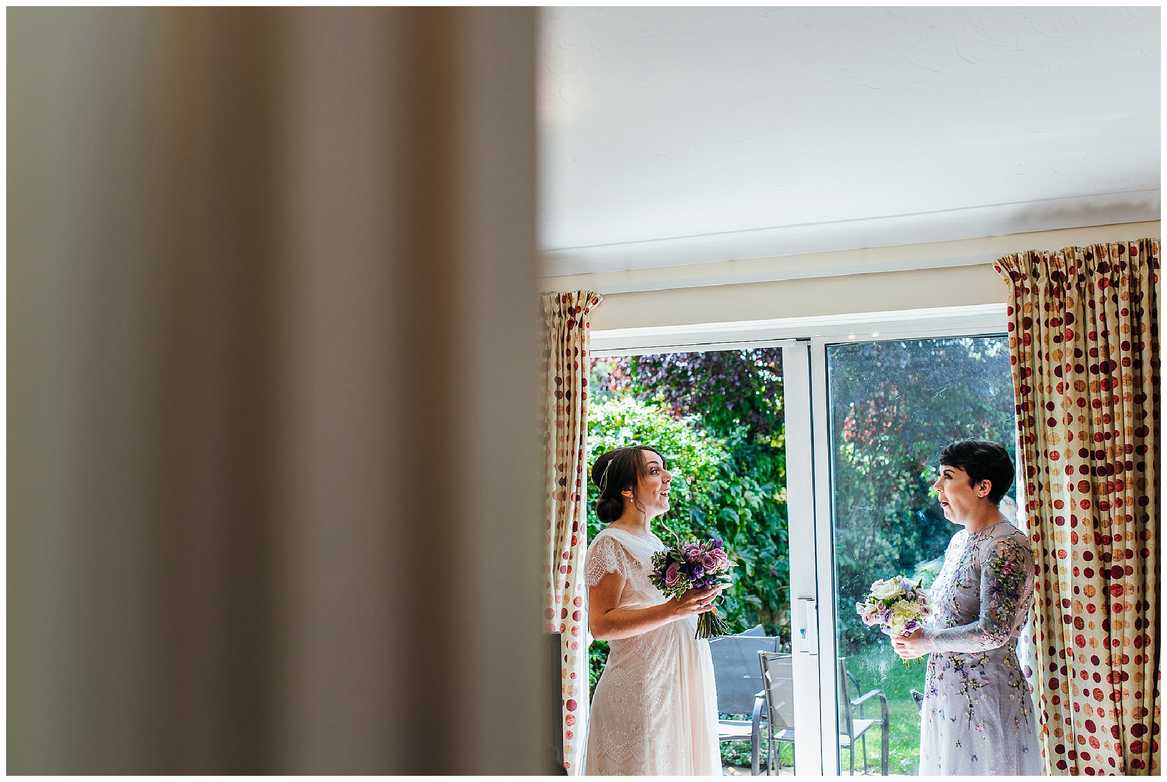 bride and friend smiling at each other nervously before leaving for wedding