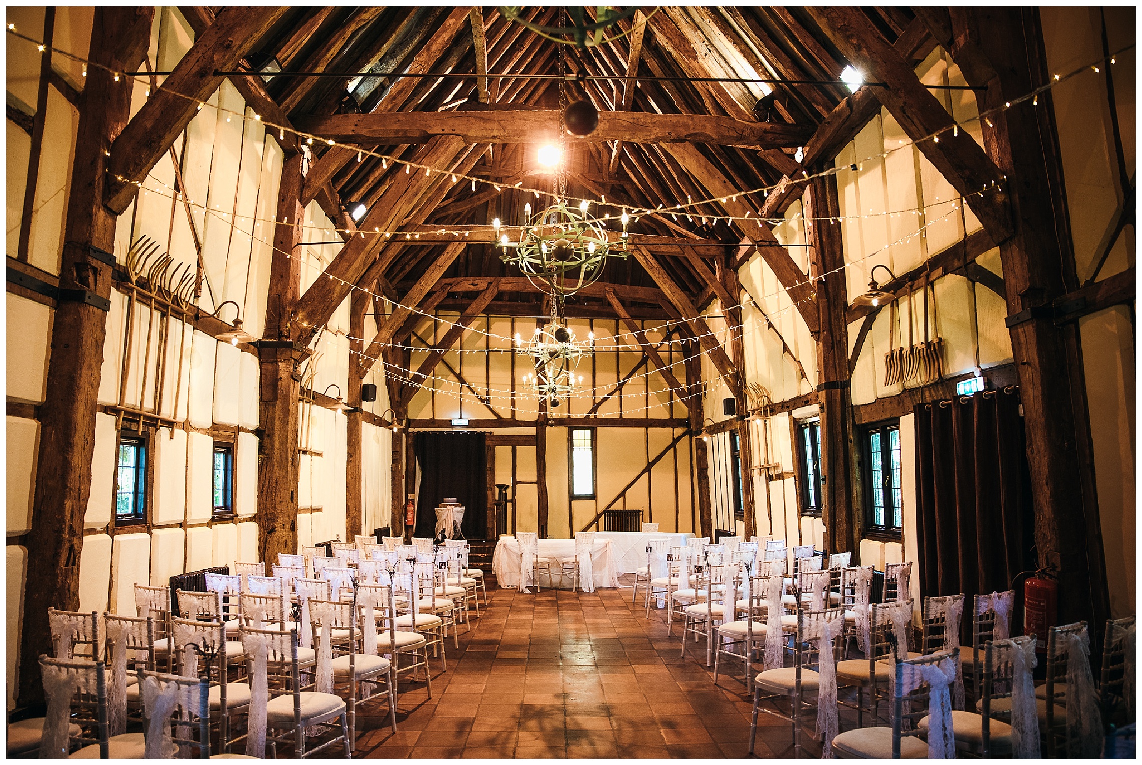 barn venue with canopy of fairy lights and old lantern chandeliers