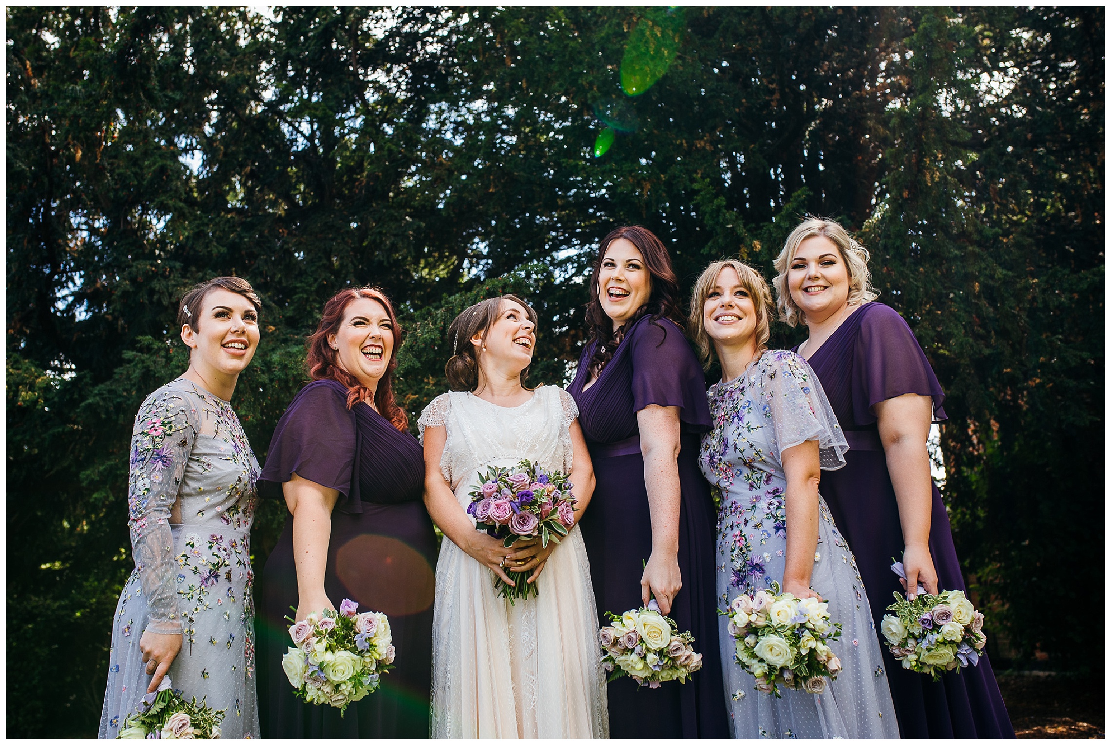 bride and her bridesmaids squeeze in together and laugh