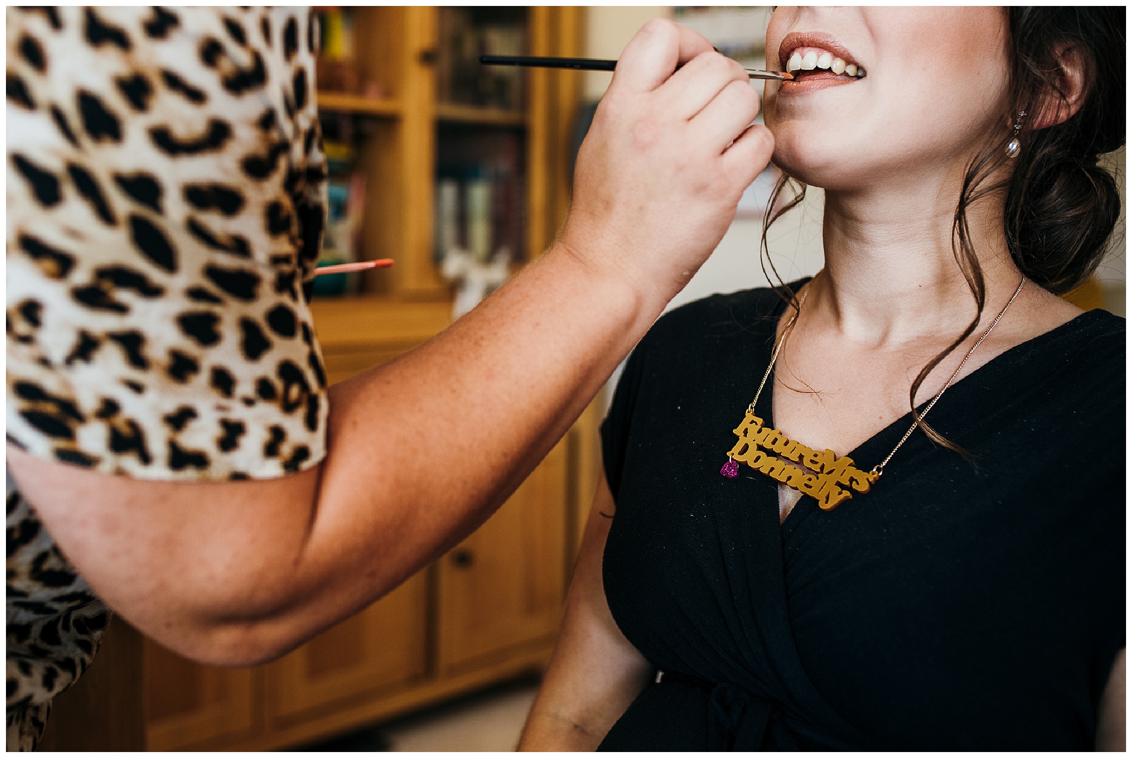 bride with gold tatty devine necklace on having lipstick applied